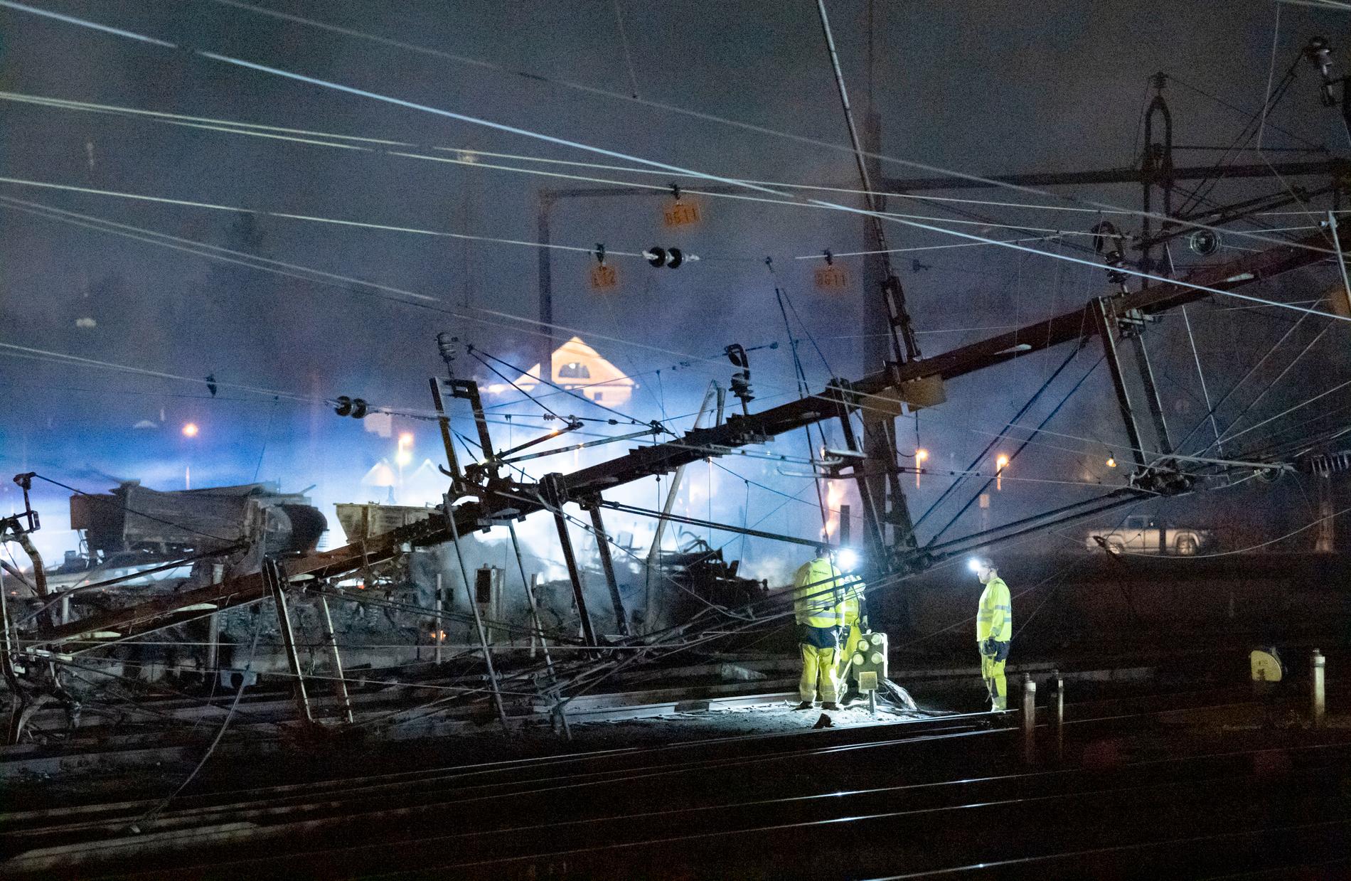 Under natten till torsdagen pågick arbete vid de kontaktledningar som fallit ner över spåren norr om stationen i Hässleholm i samband med en våldsam brand i en industribyggnad.