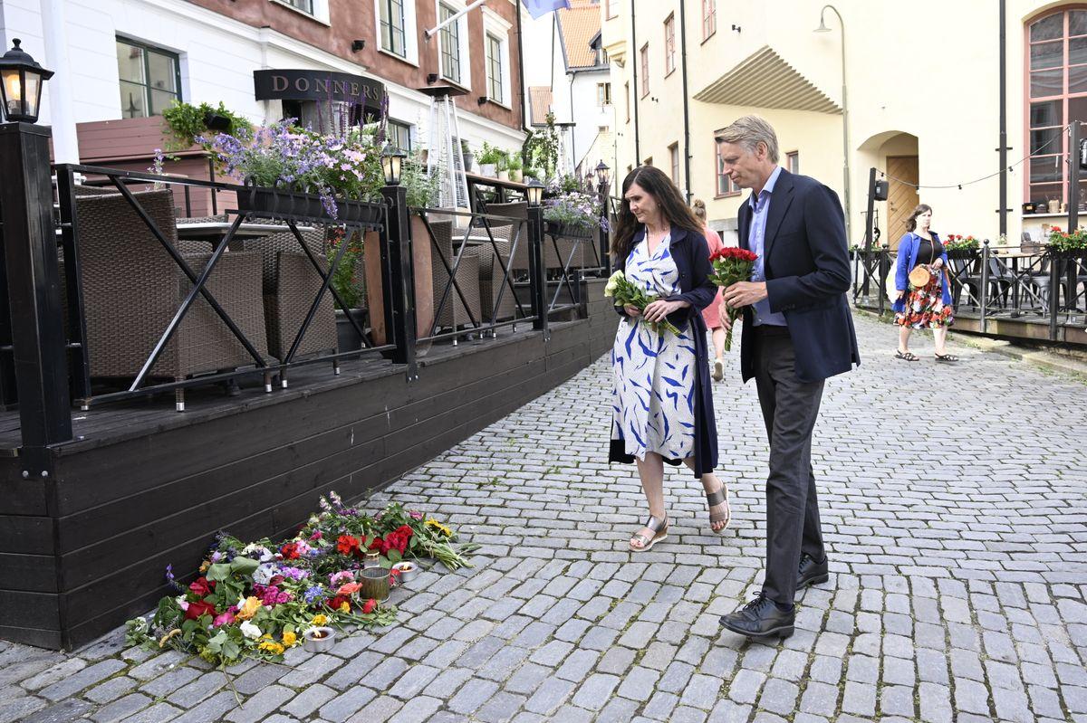 Miljöpartiets språkrör Märta Stenevi och Per Bolund lägger ned blommor vid platsen där en kvinna under gårdagen knivhöggs till döds i Visby under Almedalsveckan