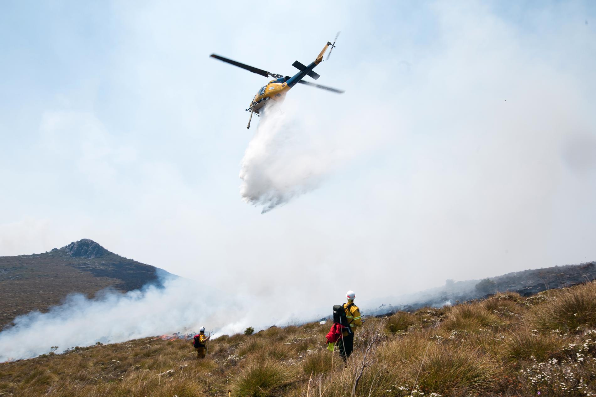 En helikopter vid släckningsarbetet vid en av de större bränderna i naturen på Tasmanien, Australien.