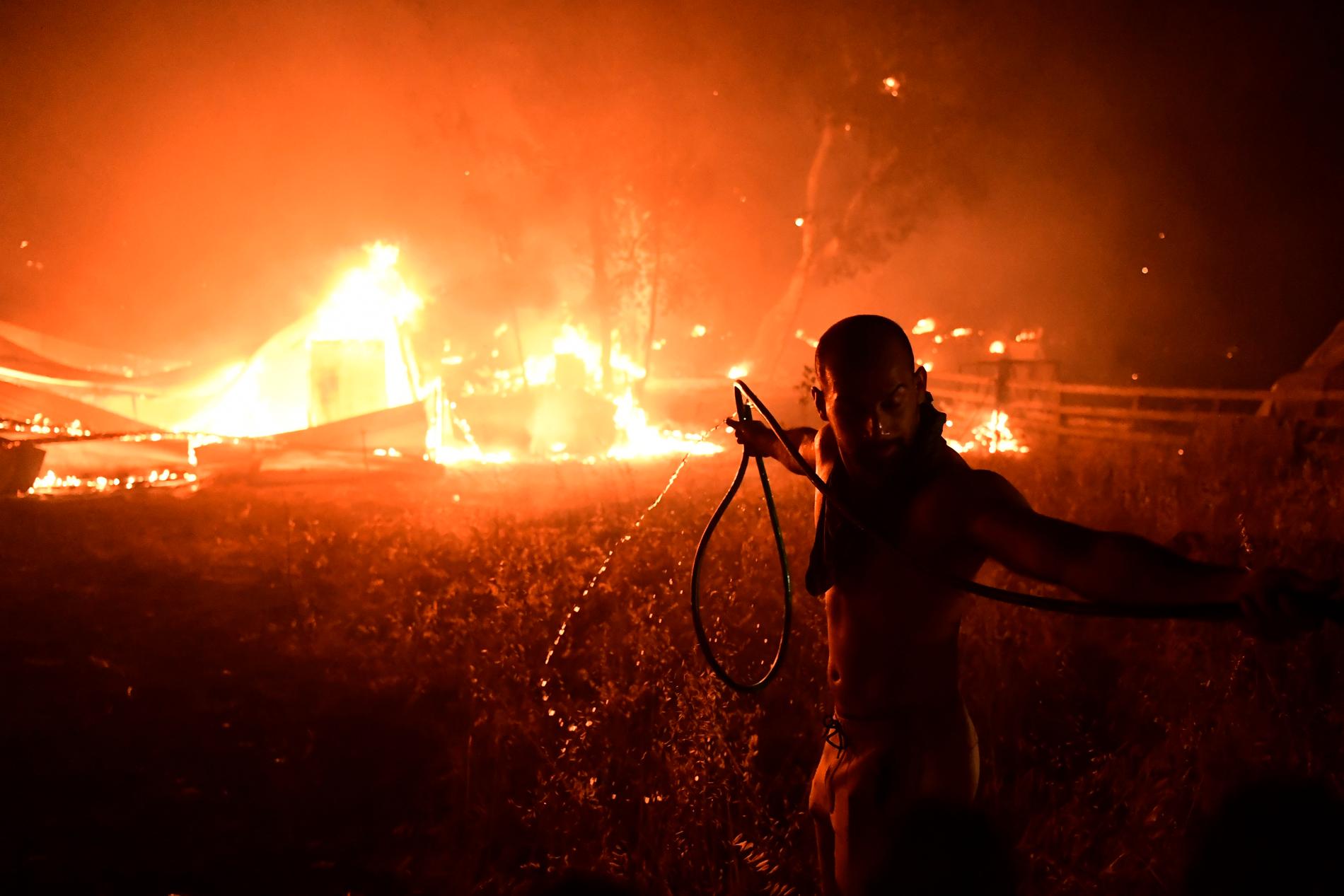 En man släcker brand i norra Aten.