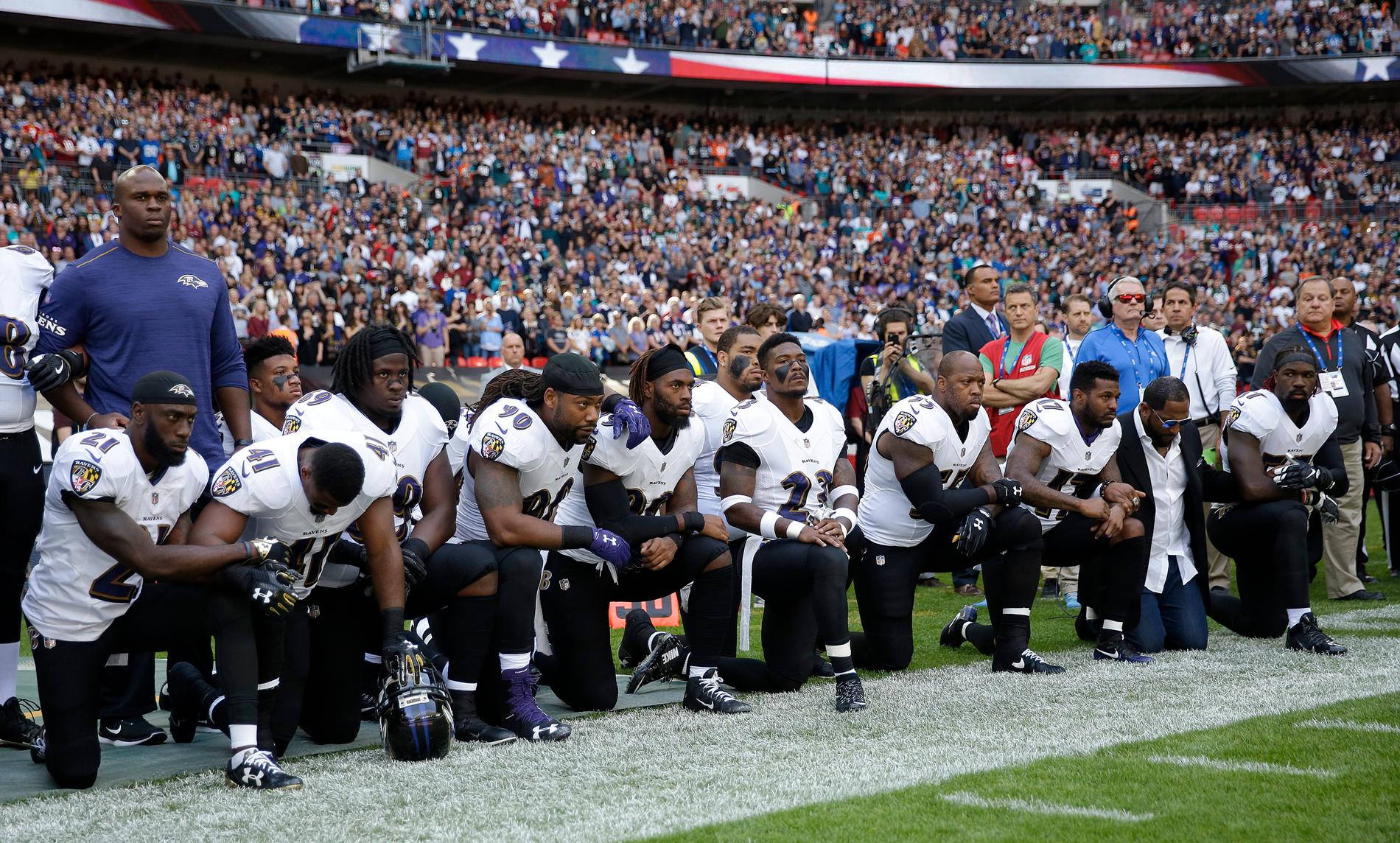 Spelare i Baltimore Raves står på knä under nationalsången.