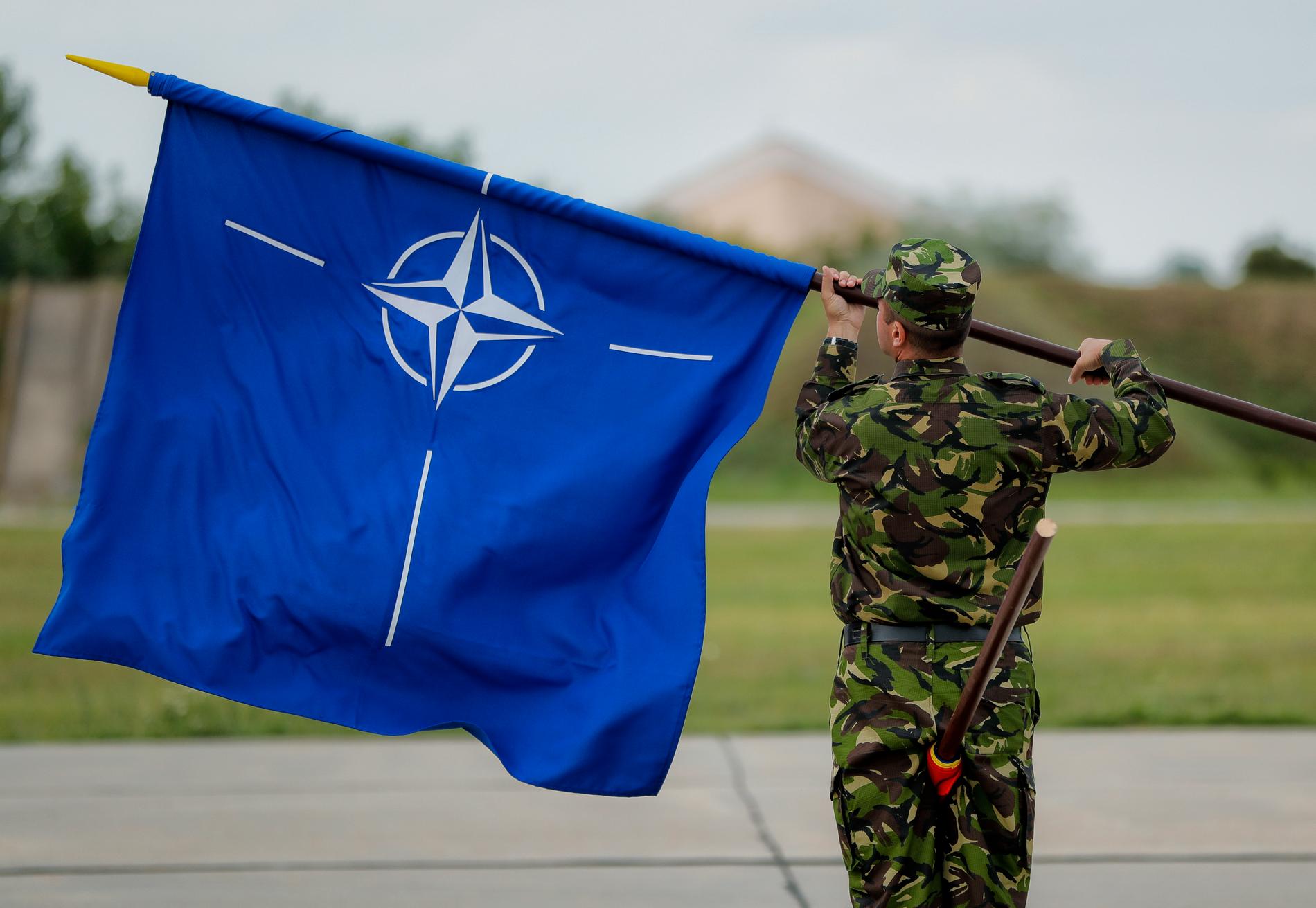 Natoflaggan, en vit kompass mot en blå bakgrund. Den blå färgen symboliserar Atlanten och ringen som innesluter kompassen står för enighet. Arkivbild.