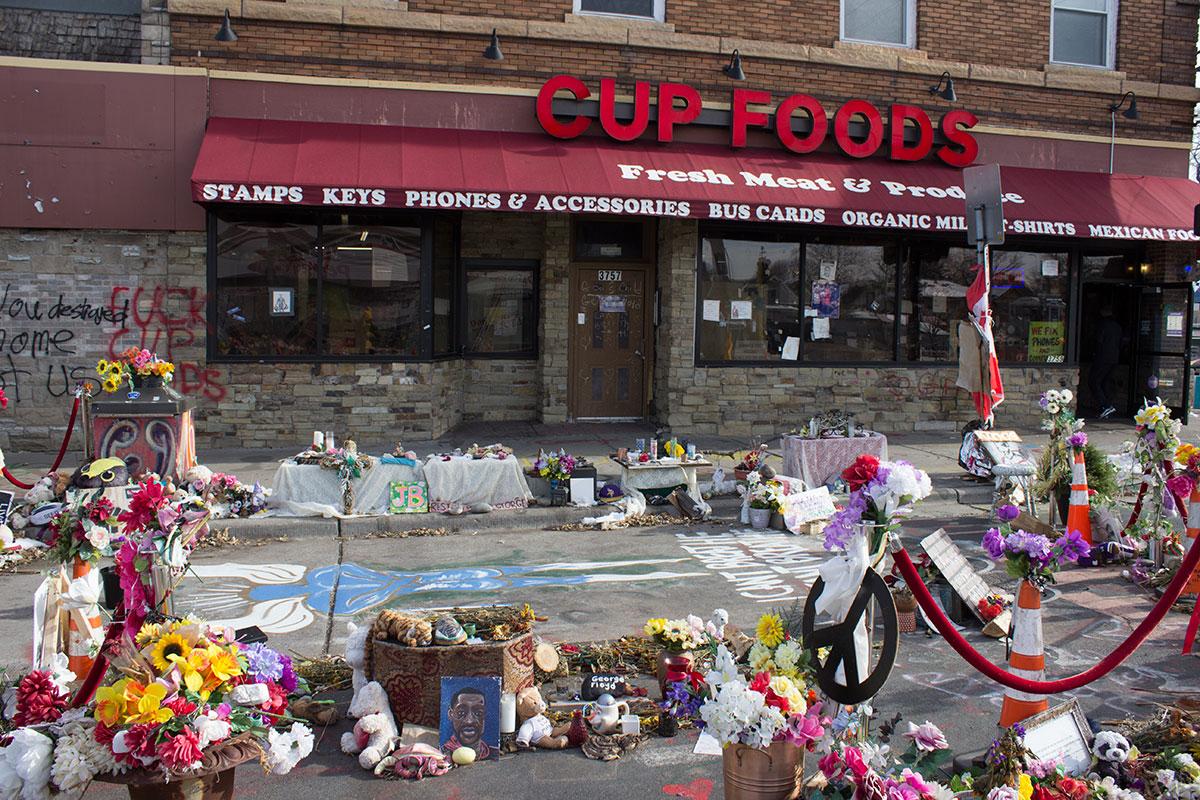 Blommor och presenter utanför butikslokalen där George Floyd dödades.