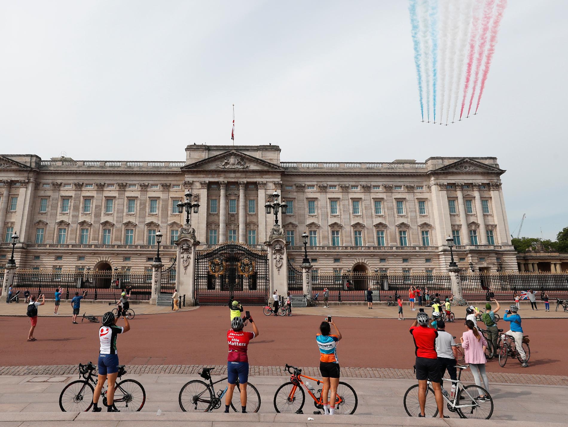 Åskådarna håller avstånd när The Royal Air Force Aerobatic Team flyger över Buckingham Palace i London.