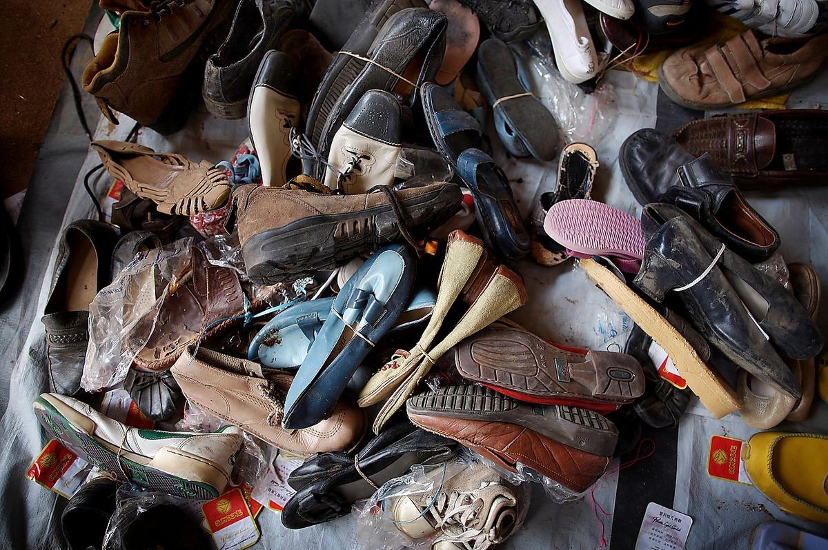 SKOR SKÄNKS BORT  Utanför grinden till lägret ligger en hög med begagnade skor som har skänkts till flyktingarna.