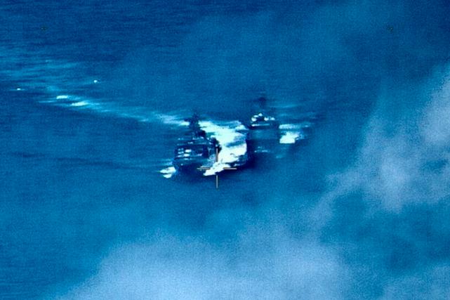 En bild släppt av den amerikanska marinen från incidenten visar den ryska jagaren Admiral Vinogradov till vänster med krökt kölvatten och den amerikanska robotkryssaren USS Chancellorsville till höger.