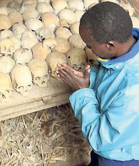 En överlevande ber vid en massgrav i Rwanda.