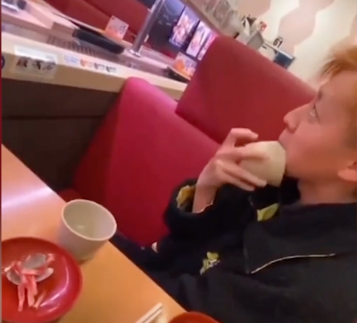 En ungdom som slickar en skål vid en sushirestaurang. Han har sedan bett om ursäkt till ägaren.