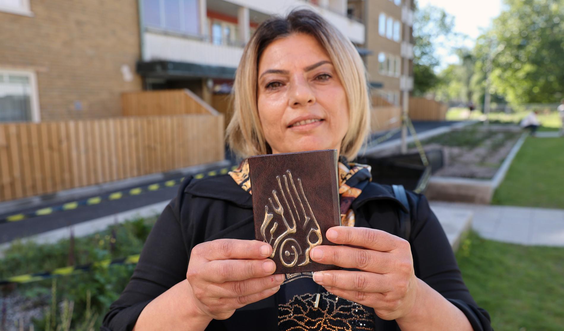 Fida, 53, håller upp en koran. Hon är upprörd på polisen.