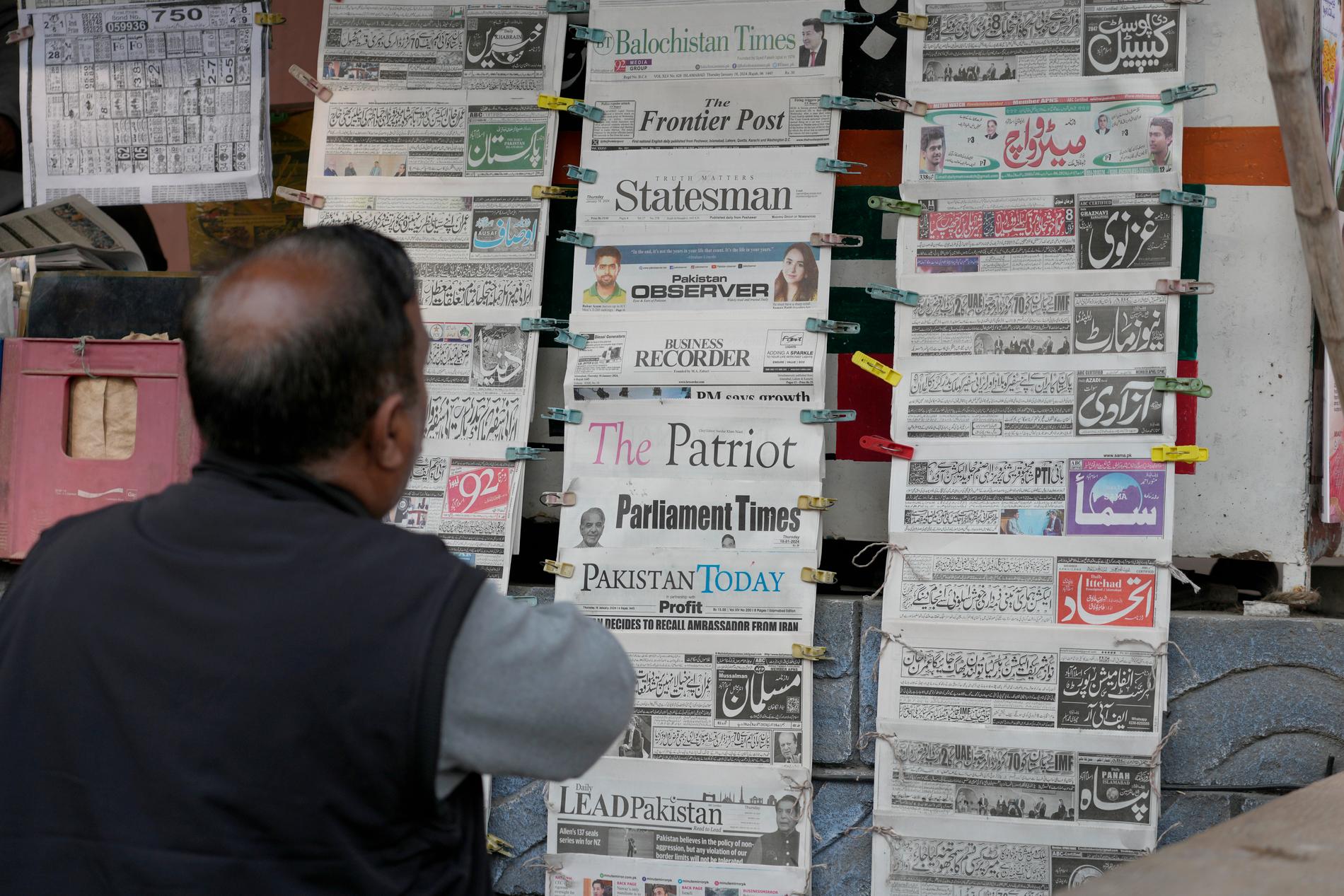 En pakistanier tittar under torsdagsmorgonen på dagstidningar som rapporterar om Irans attack i Pakistan i tisdags. Tidigt på torsdagen utförde Pakistans flygvapen liknande attacker i Iran.