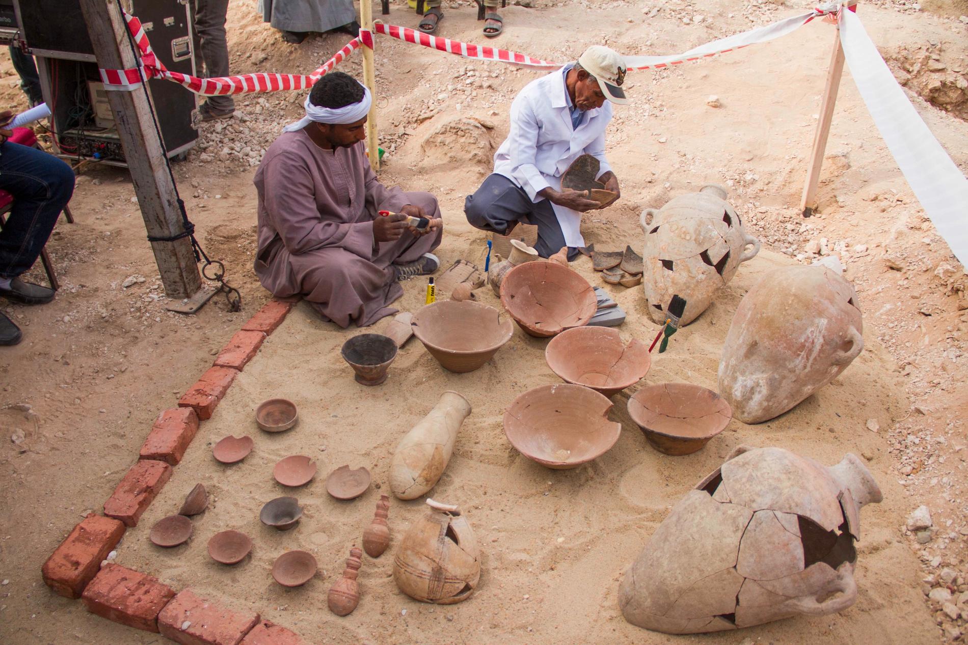 Arkeologer arbetar med att restaurera lergods nära den nyligen upptäckta graven.