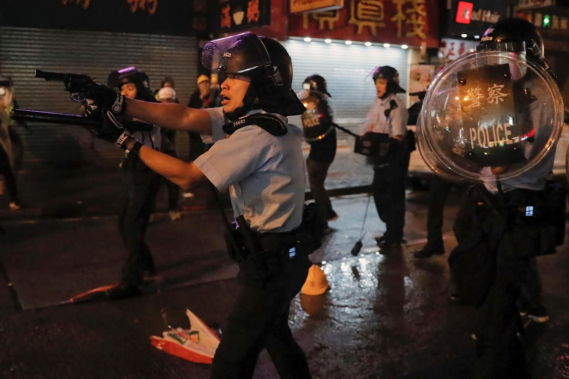 Flera poliser drog sina vapen under protesterna i Hongkong på söndagen. Minst ett skott har avlossats, enligt polisen.