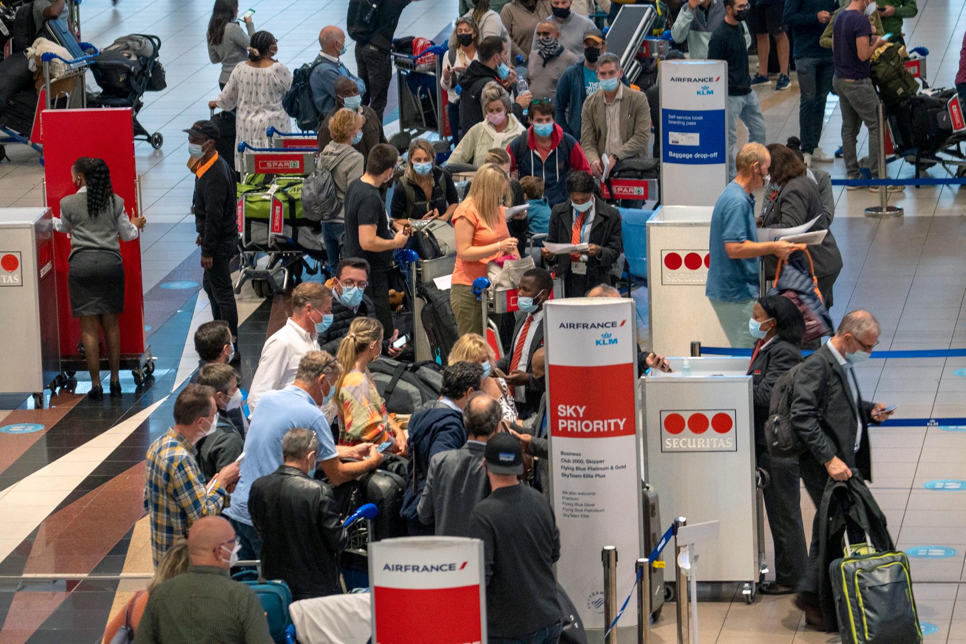 Långa köer på Johannesburgs internationella flygplats efter att larmet om den nya virusvarianten fått många länder att införa flygstopp för resenärer från Sydafrika.