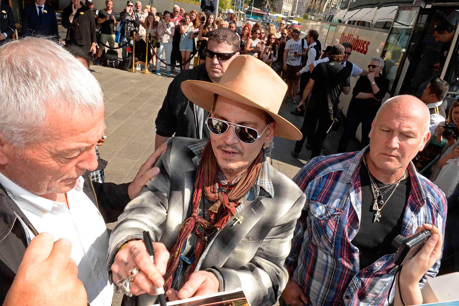 Johnny Depp skriver autografer utanför Grand Hôtel.