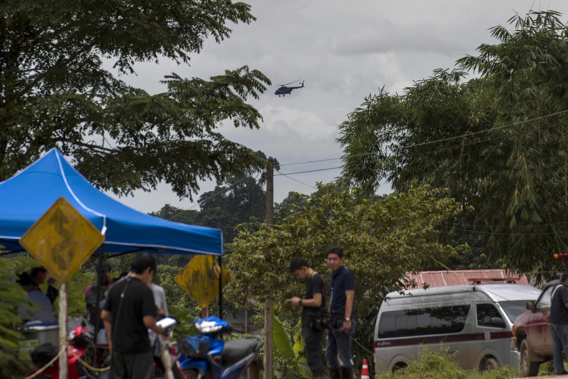 En militärhelikopter flyger över Tham Luang-grottan under räddningsarbetet.