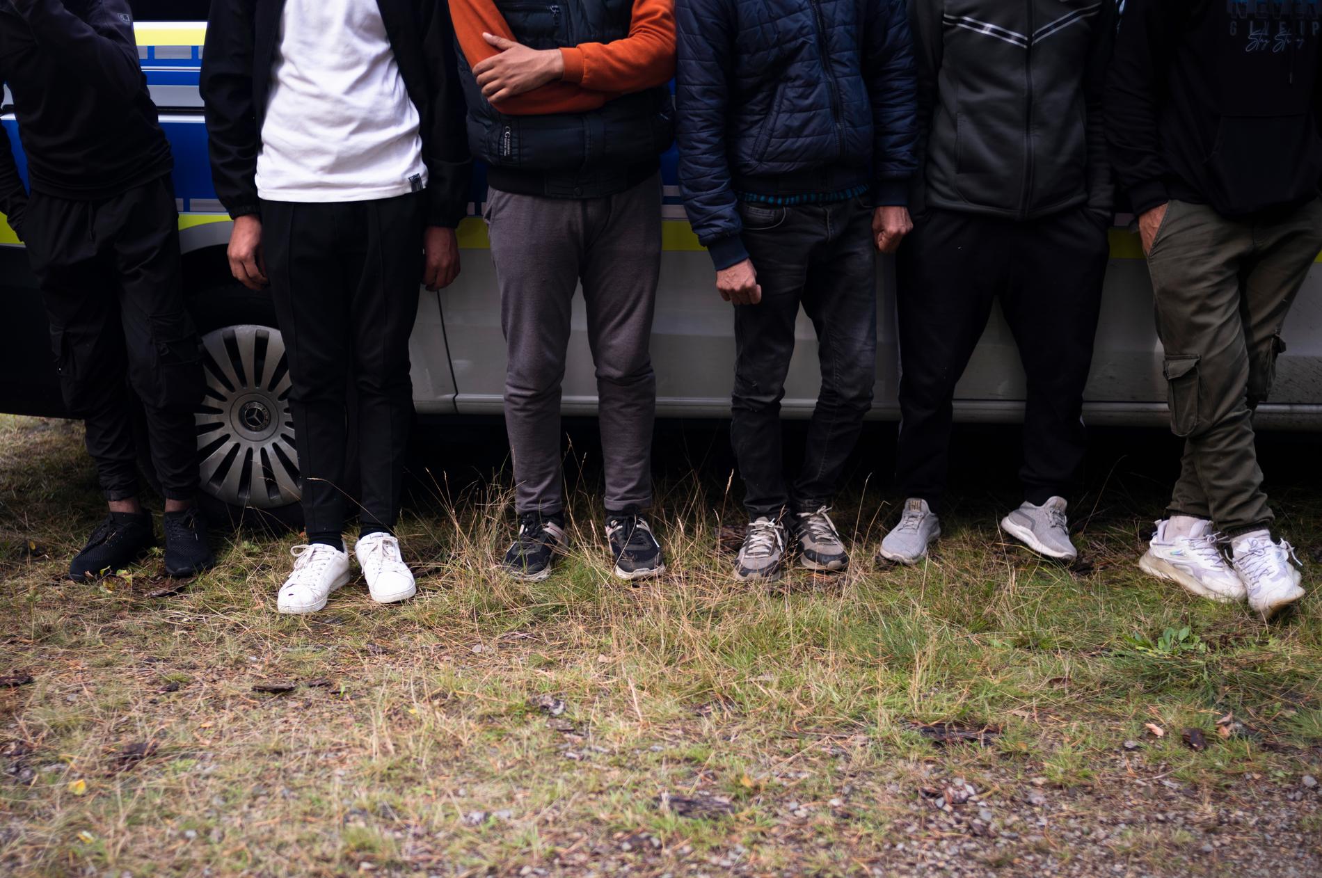 Migranter väntar vid en polisbil efter att de olagligt korsat gränsen från Polen till Tyskland.