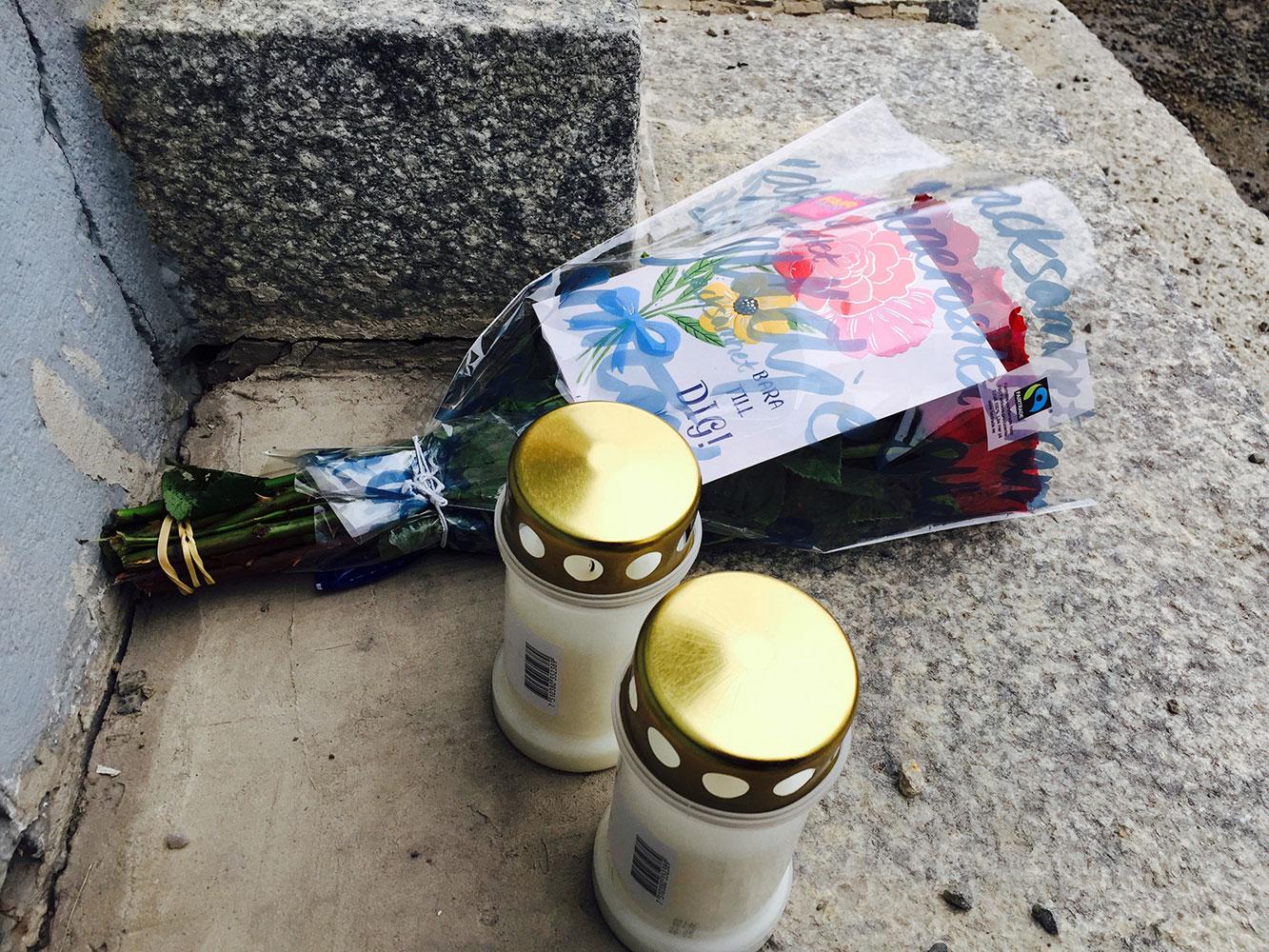 Blommor och ljus för att minnas och hedra offret.