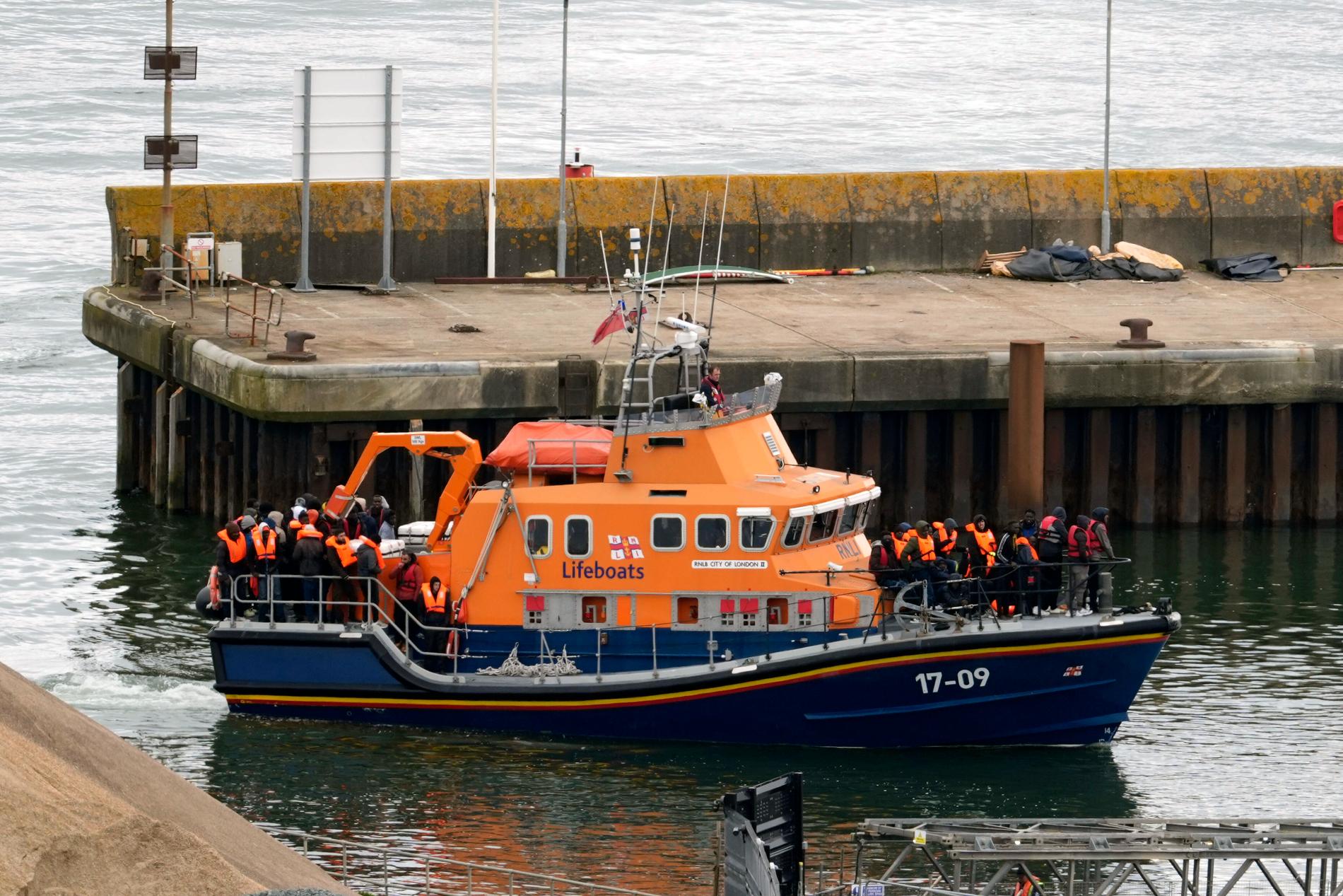 Händelsen sker samtidigt som Storbritanniens premiärminister Rishi Sunak vill avskräcka den farliga flyktingsmugglingen över Engelska kanalen. Bild på människor som tros vara migranter som förs till Dover i England.