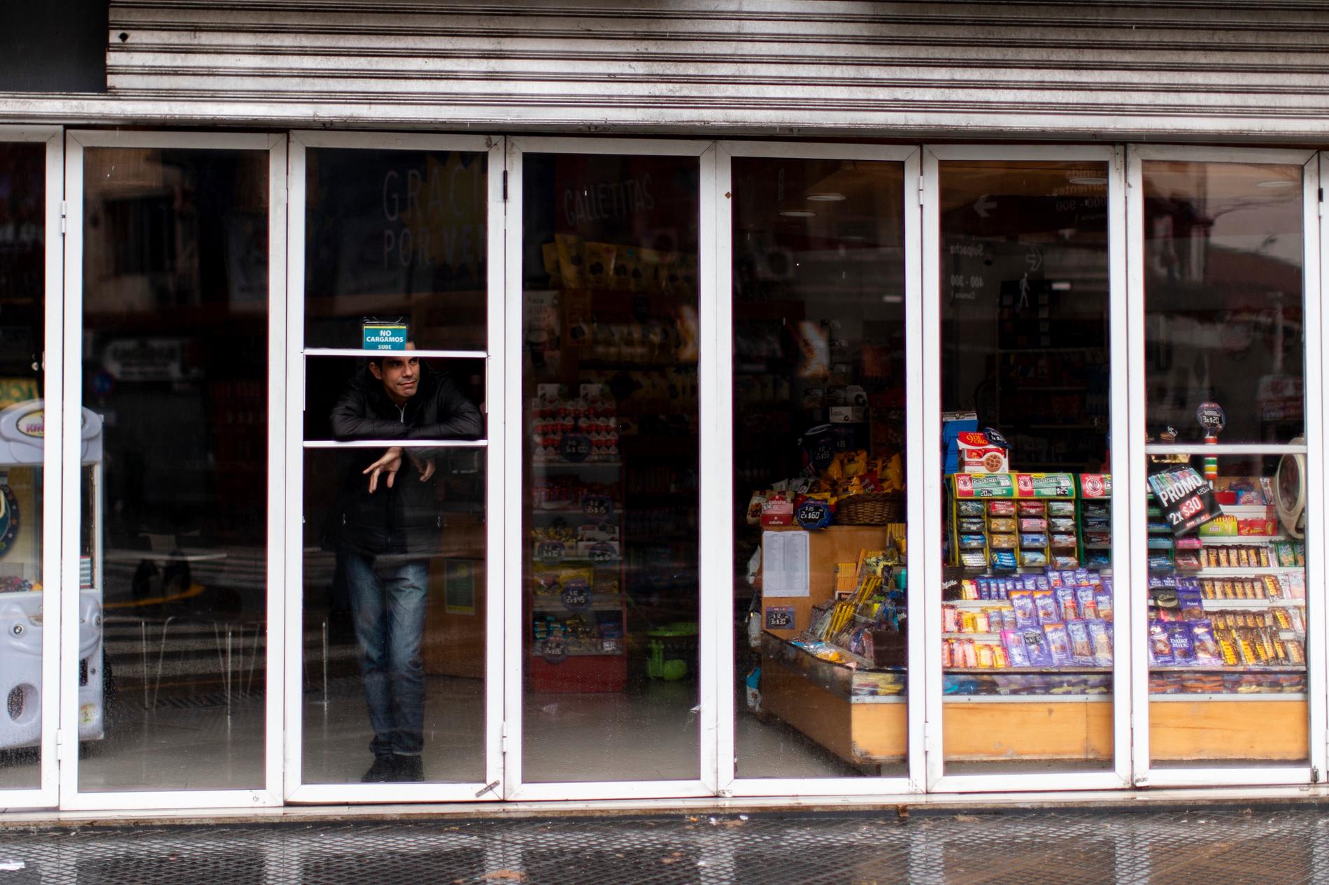 En man står inne i en nedsläckt affär i Buenos Aires i Argentina som drabbats av det omfattande strömavbrottet i Sydamerika på söndagen.