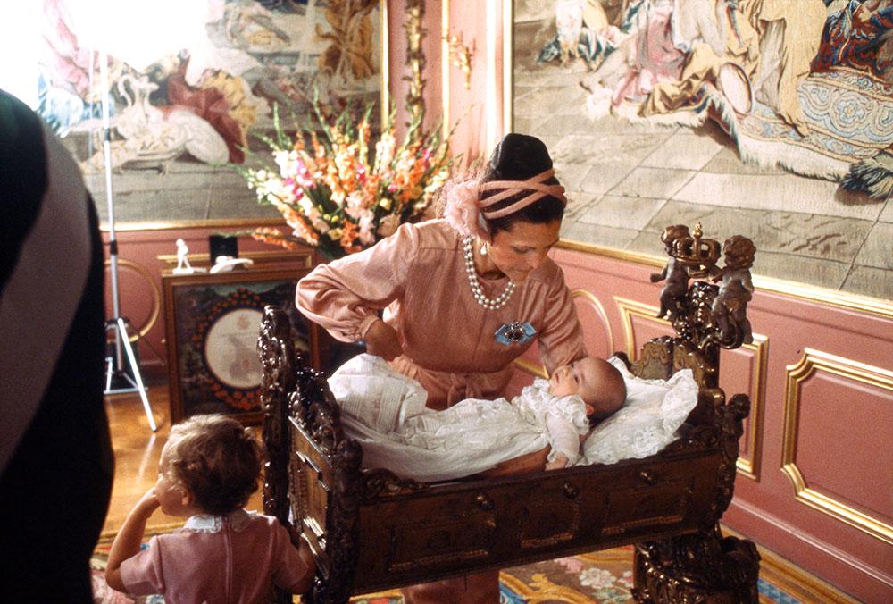 Drottning Silvia med lille Carl Philip på hans dopdag 1979. Han föddes som kronprins men blev av med titeln när den nya successionsordningen trädde i kraft 1980 till förmån för Victoria. 