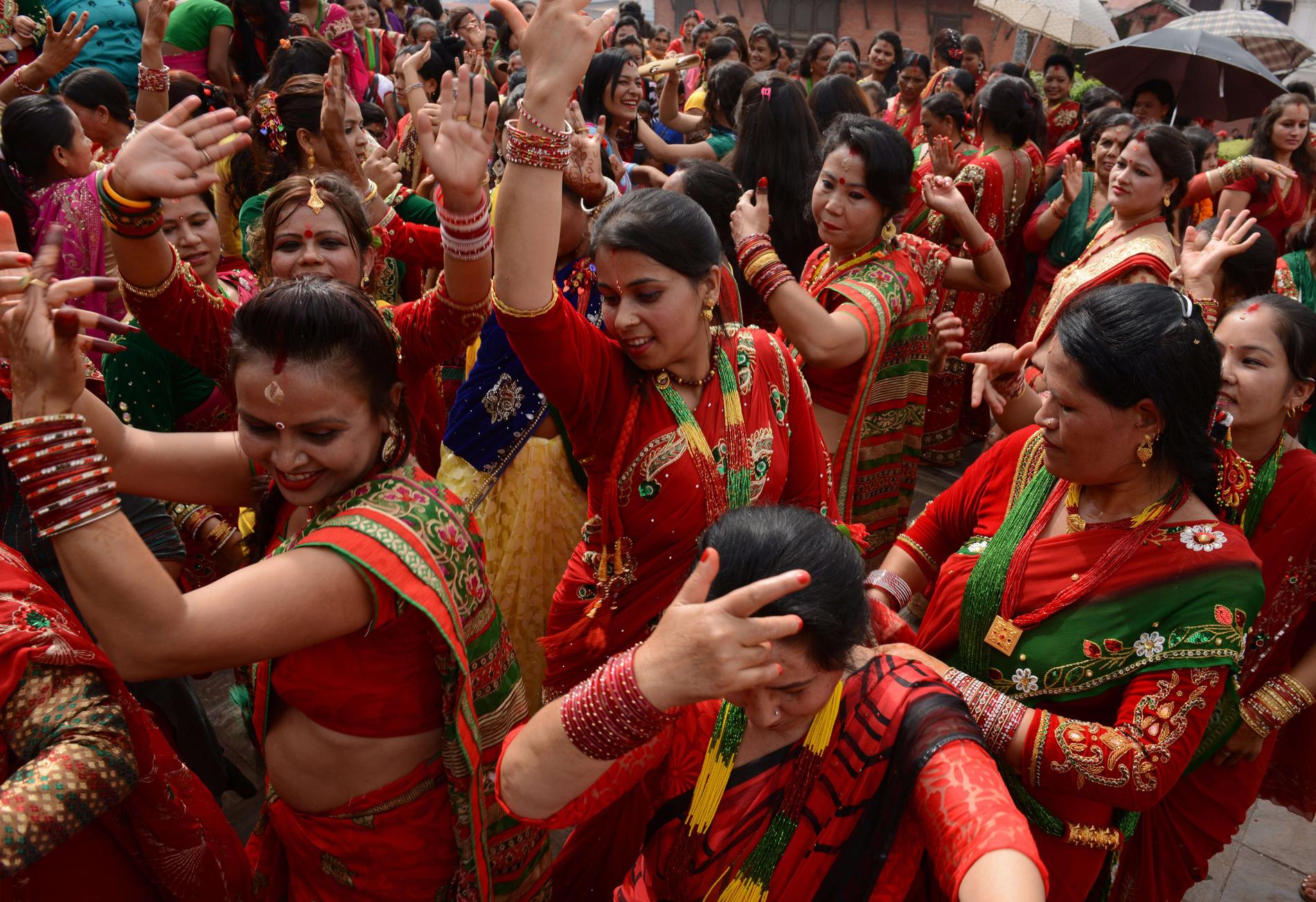 Rödklädda hinduiska kvinnor dansar till Shivas ära under Teejfestivalen i Katmandu, Nepal.