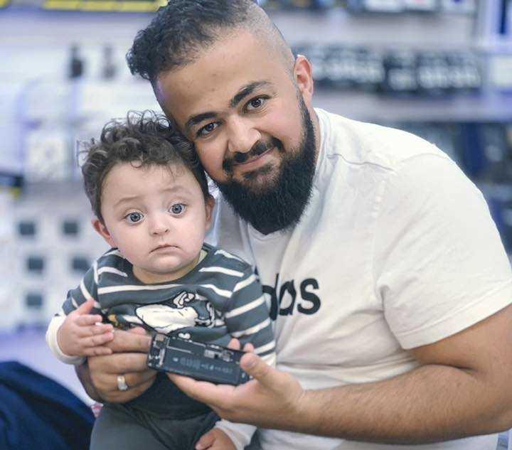 Karar Al Husseini, här med sin son, skänker munskydd till personer i riskgrupper.