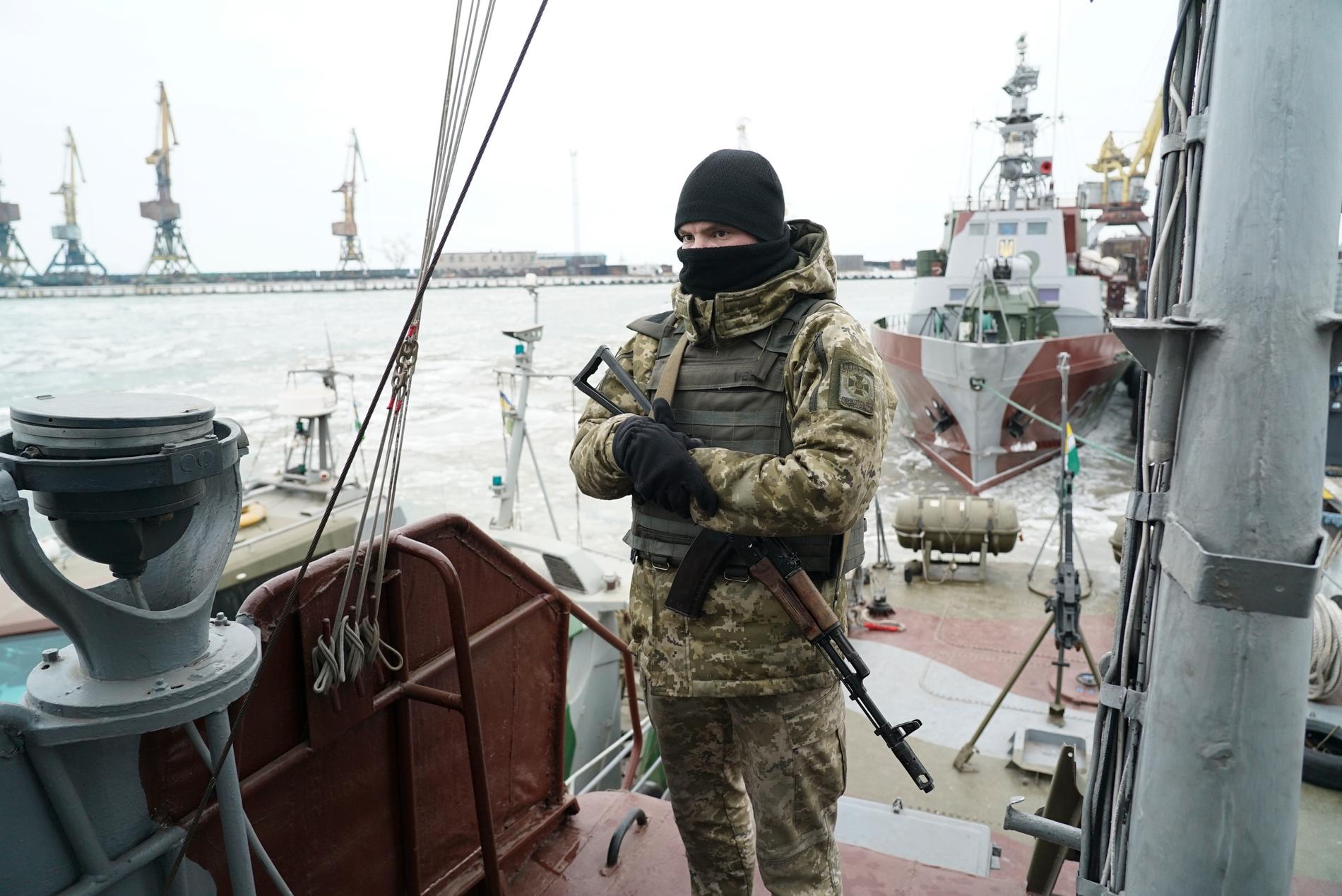 En ukrainsk soldat på vakt i hamnen i Mariupol vid Azovska sjön. Rysslands agerande mot ukrainska fartyg i området kan nu leda till sanktioner från EU. Arkivbild.