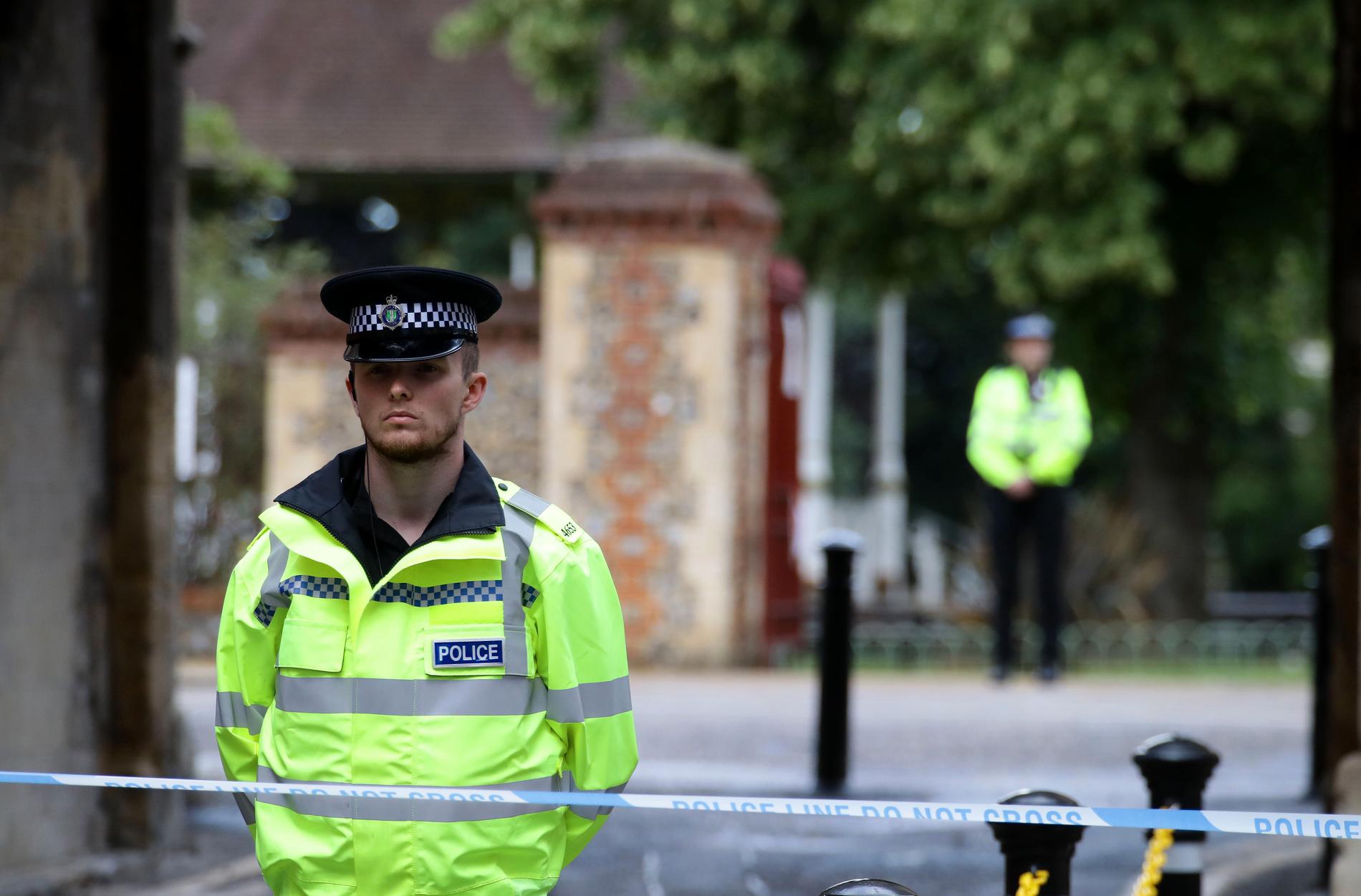 En polis står vakt utanför Forbury Gardens i Reading där knivattacken ägde rum.