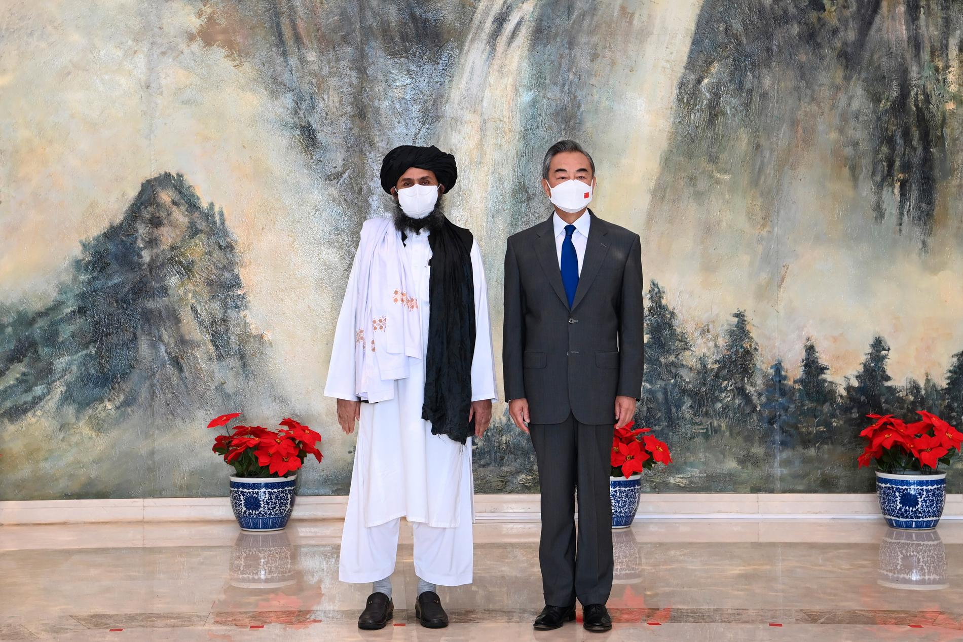 Talibanledaren Mullah Abdul Ghani Baradar och Kinas utrikesminister Wang Yi under onsdagens möte i Tianjin.