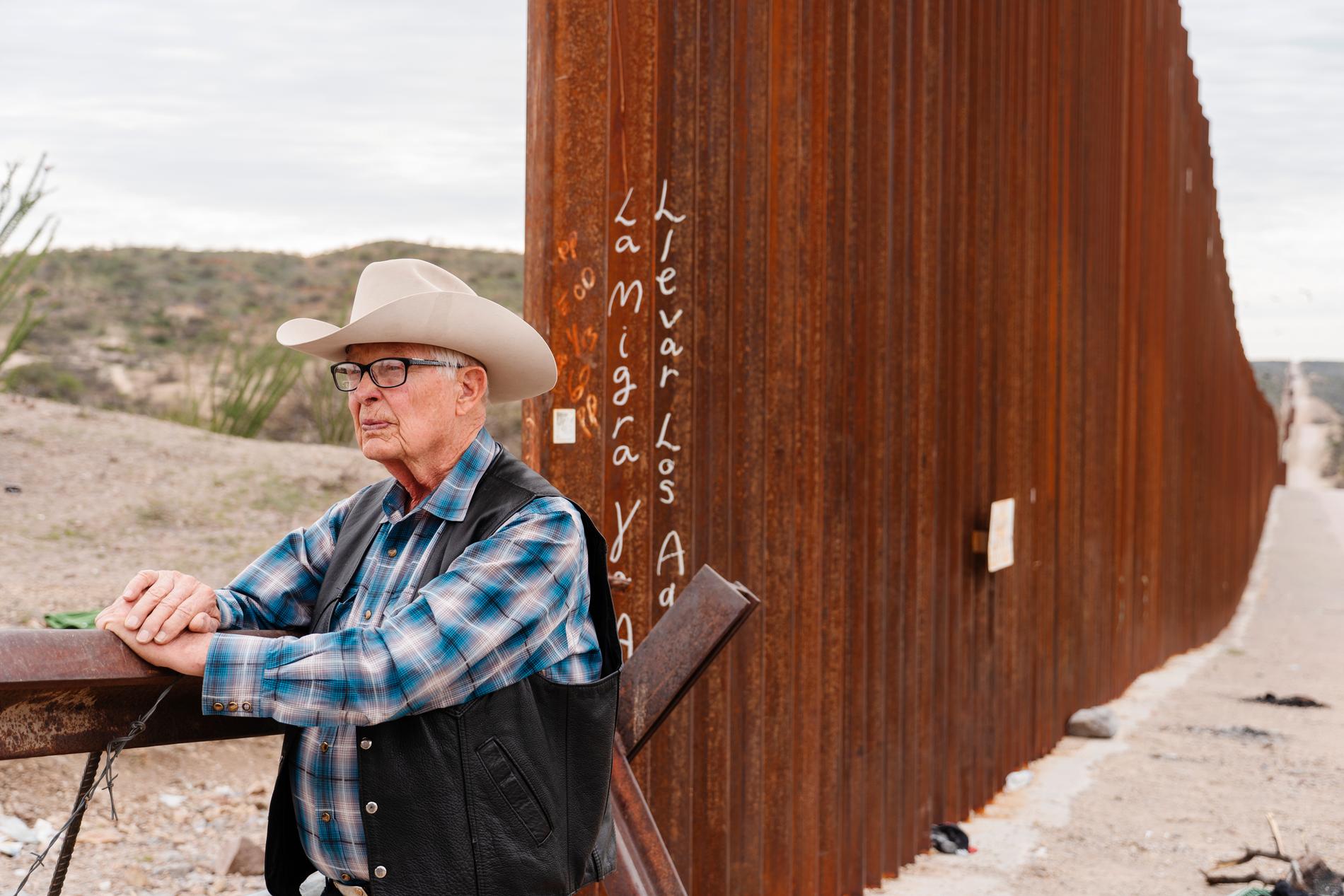 Jim Chilton vid en öppning i det höga gränsstaket som byggdes under Trumps tid som president. Nu hoppas han att det ska byggas färdigt.