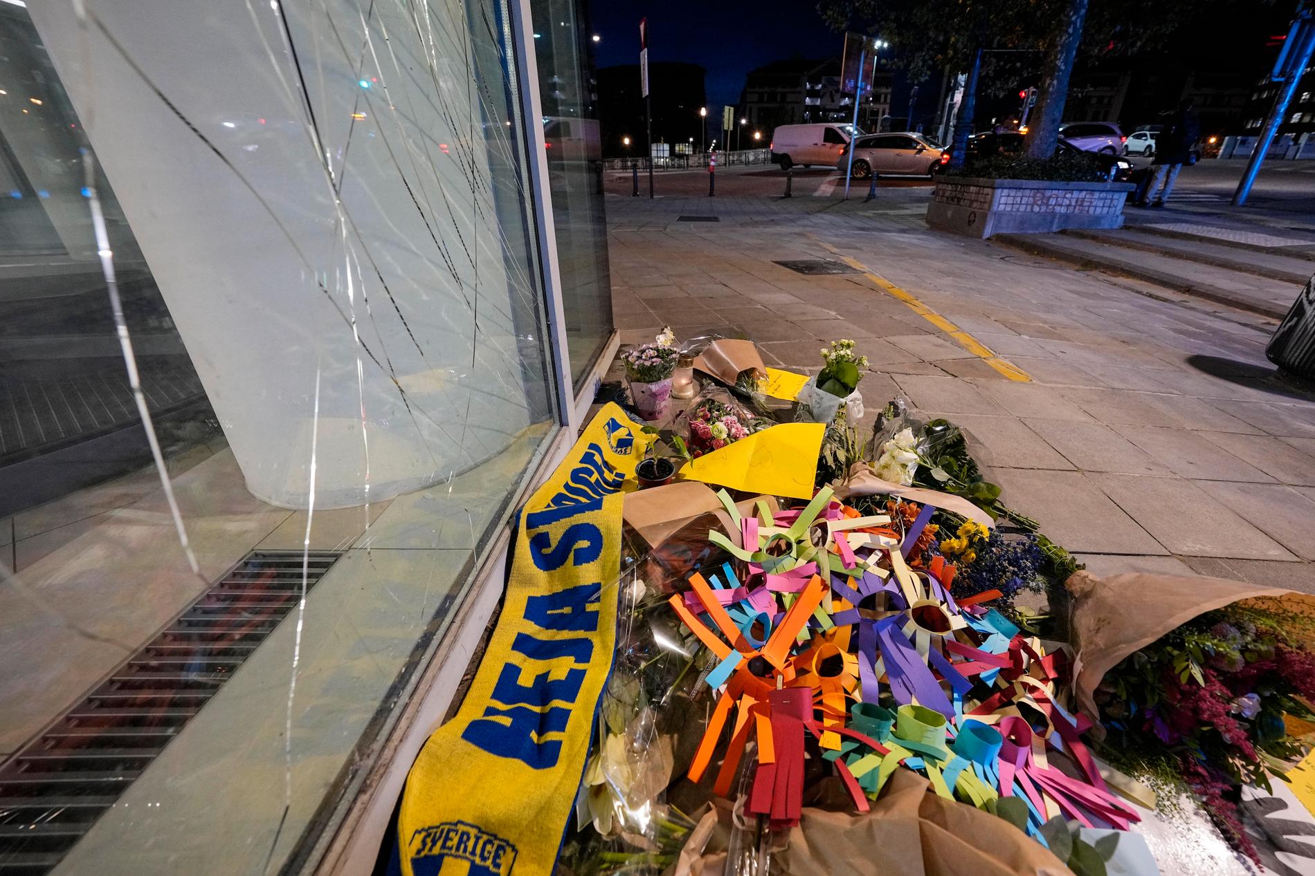 Folk har lämnat blommor och Sverigehalsdukar vid mordplatsen.