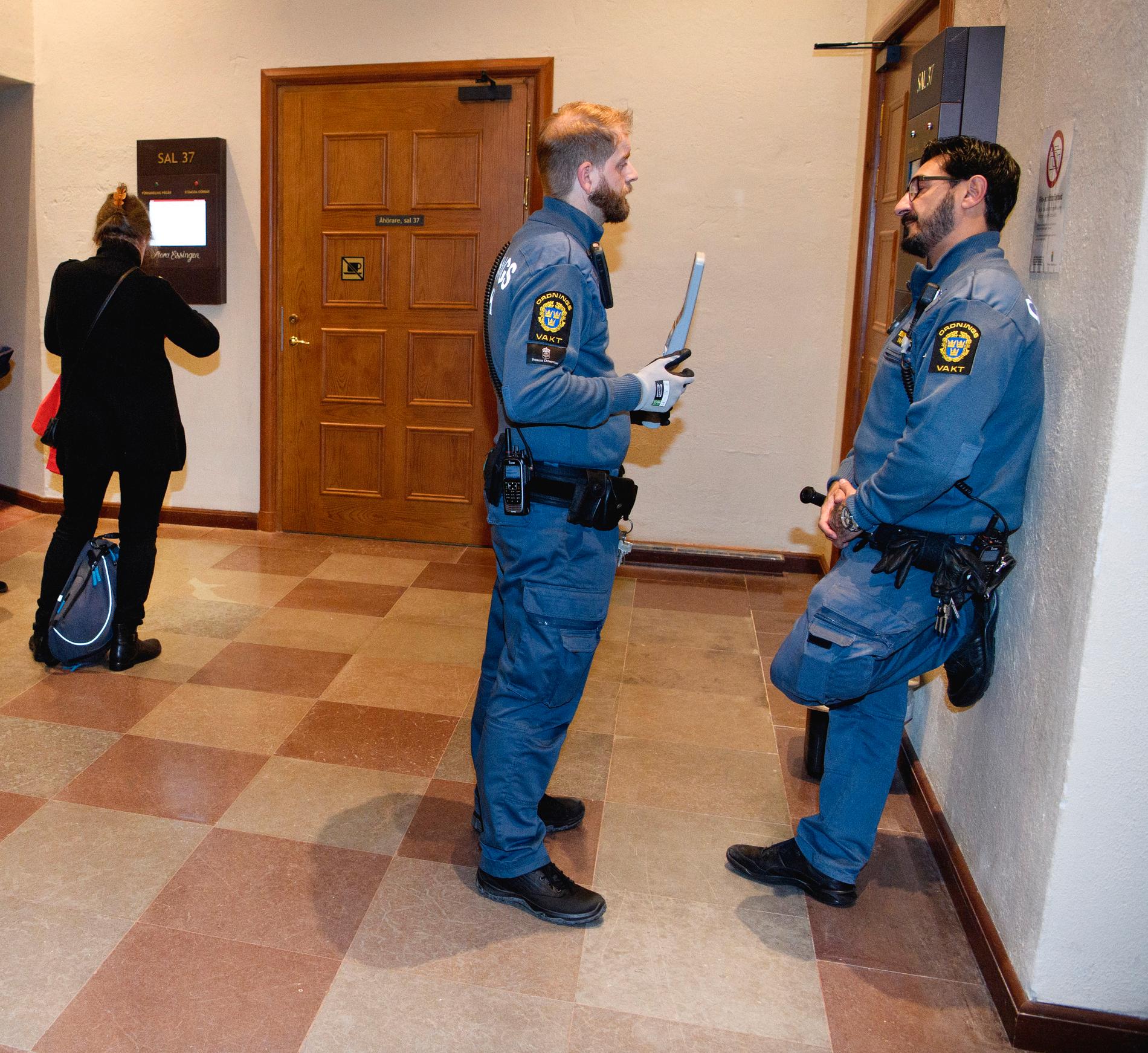Vakter på plats i Stockholms tingsrätt under första rättegångsdagen mot toppjuristen.