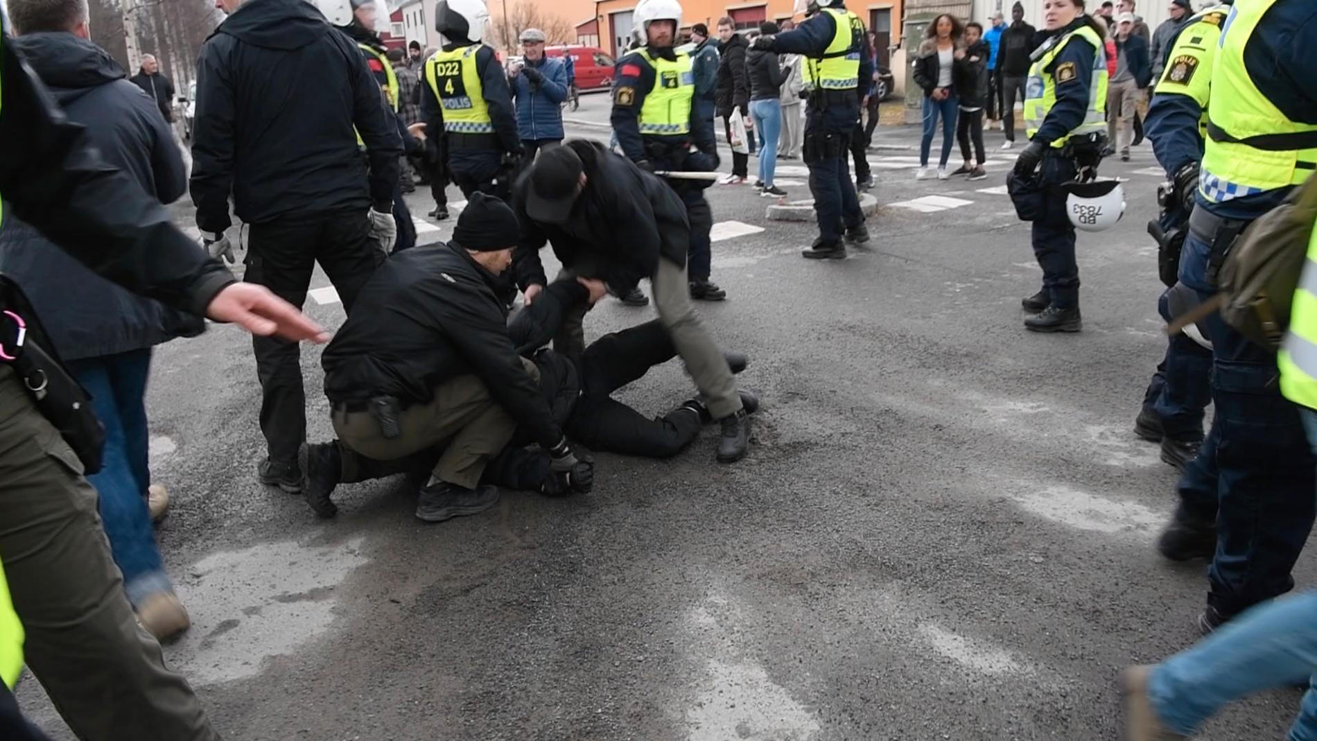 Civilklädd polis omhändertar en person i Boden. 