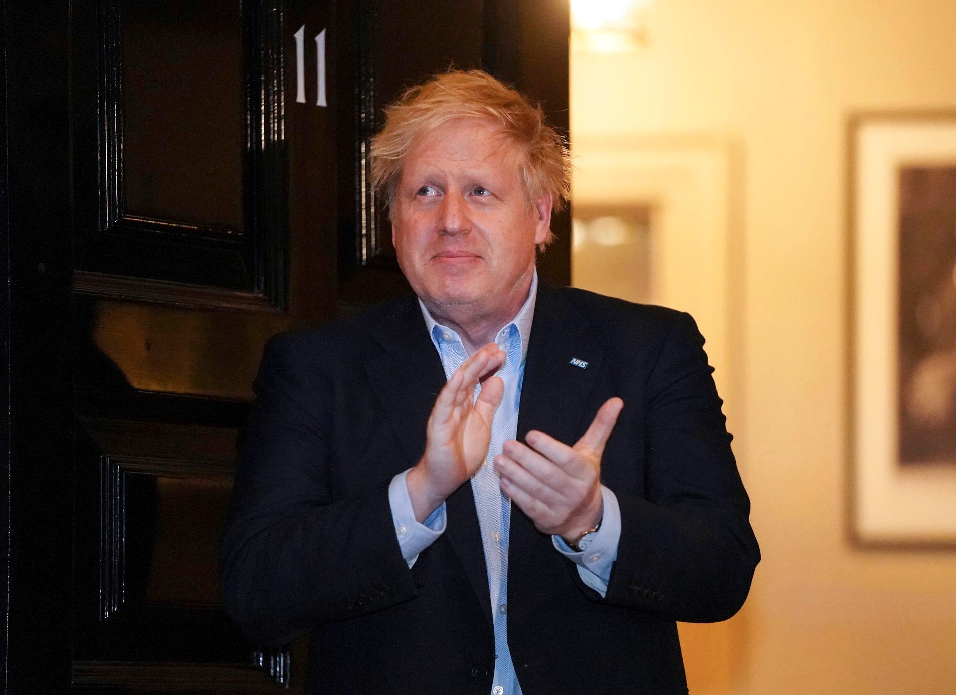 Boris Johnson klappar händerna för sjukvårdspersonal utanför Downing Street 11.