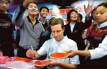 Jan-Ove Waldner signerar bordtennisracketar vid ett besök i staden Zhang Jiagang i Kina.