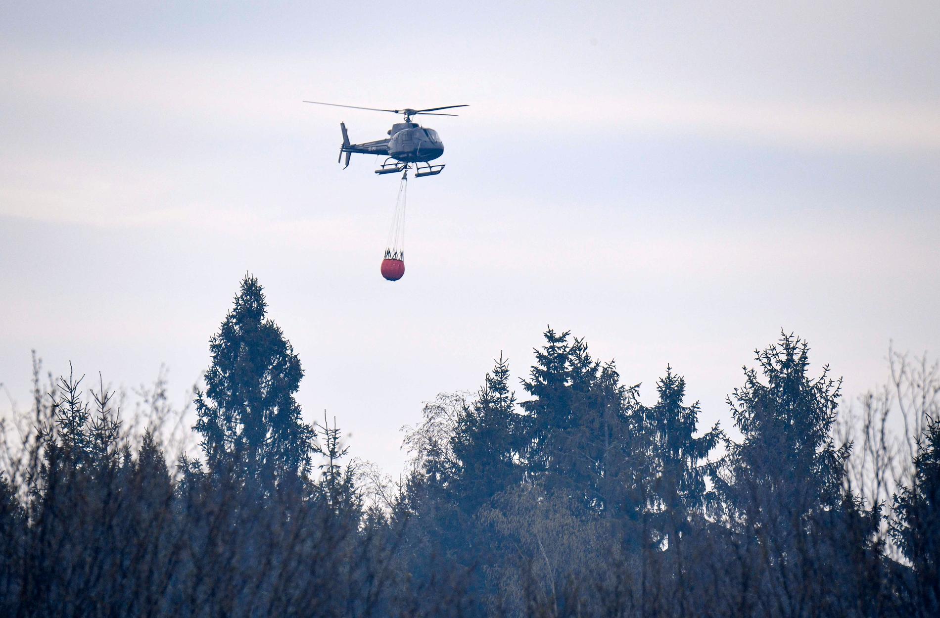 Skånska Hästveda i april i år: en helikopter vattenbombar den omfattande skogsbranden som drabbat orten. Arkivbild.