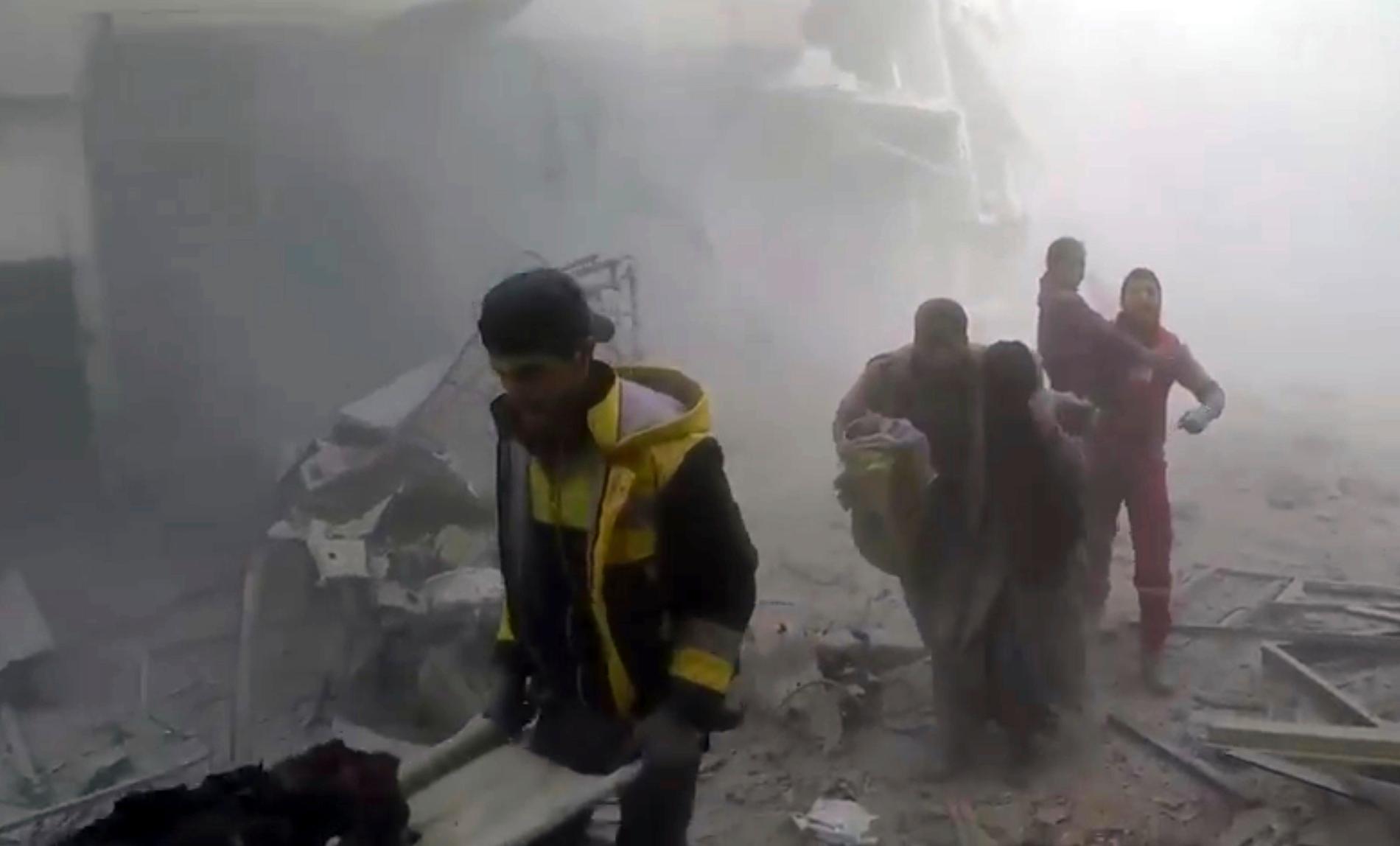 Medlemmar ur frivilligkåren Vita hjälmarna hjälper skadade efter fler luftanfall mot östra Ghouta på lördagen.