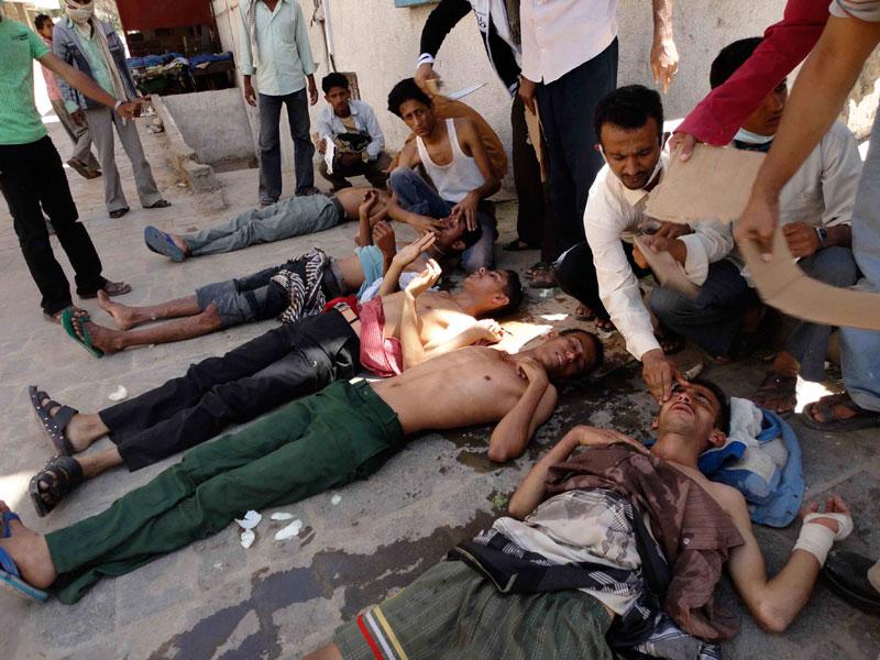 Demonstranter får behandling efter att ha andats in tårgas vid sammandrabbningar med polis i Taiz i södra Jemen.