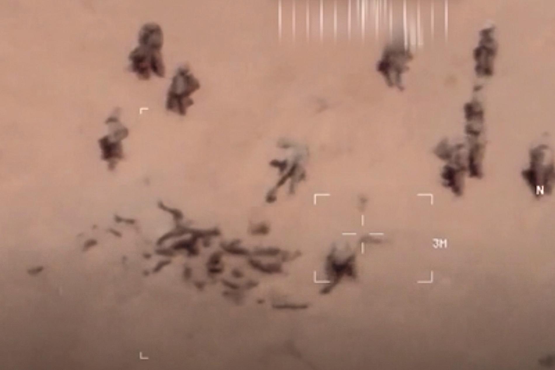 Bilder från den franska armén påstås visa beväpnade män som begraver kroppar i sanden intill en miltärbas i norra Mali. 