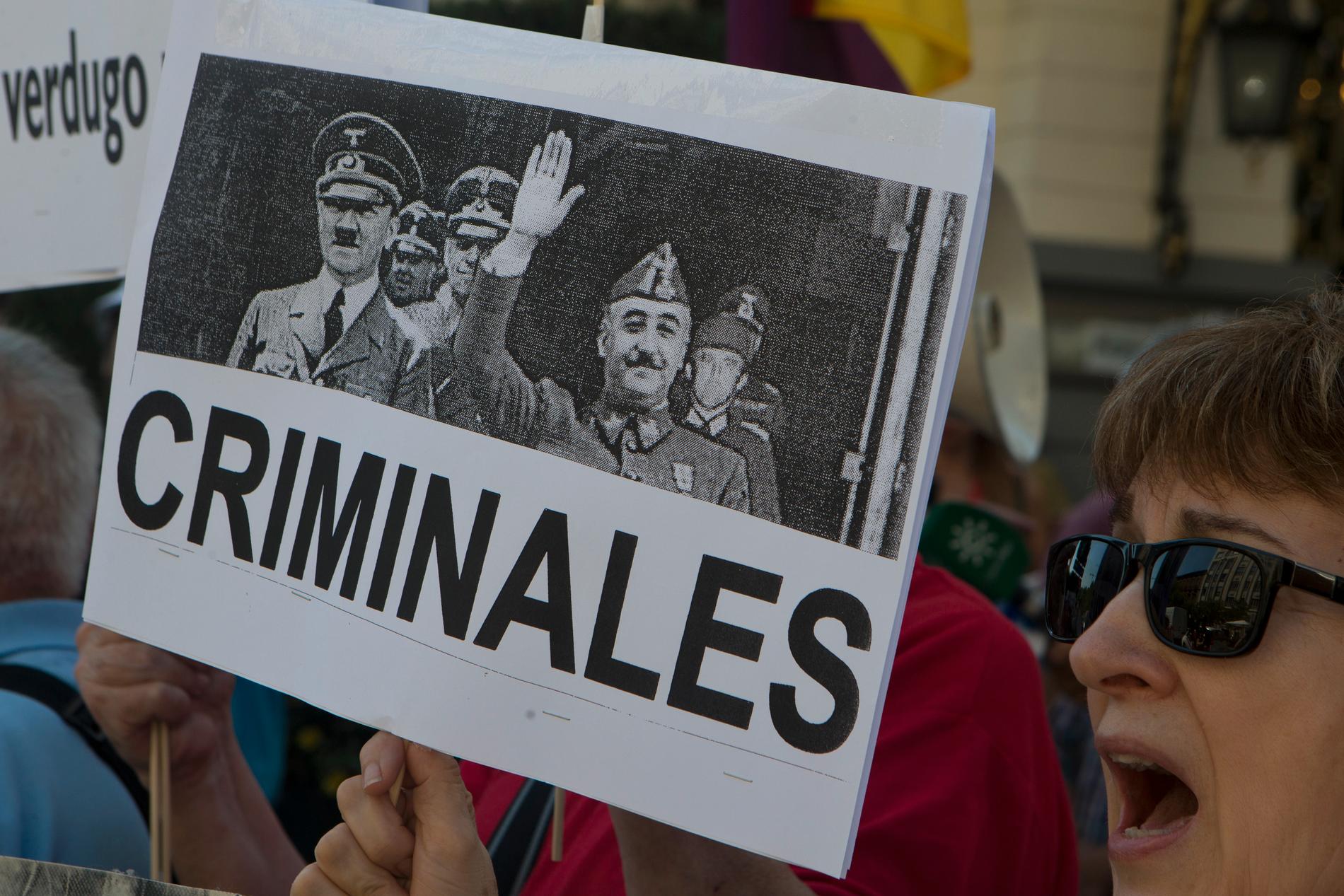 "Kriminella". En demonstrant i Madrid i september 2018 med en bild på Francisco Franco och Adolf Hitler. Arkivbild.
