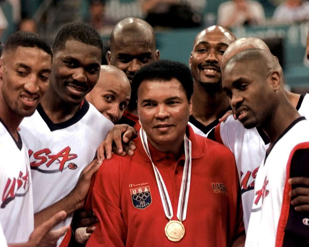 Muhammad Ali påstås ha kastat sin guldmedalj från OS 1960 i Ohiofloden efter att ha vägrats service på en restaurang som bara serverade vita. Under OS i Atlanta 1996 fick han en ny. Här flankeras han av medlemmar i USA:s basketlag.