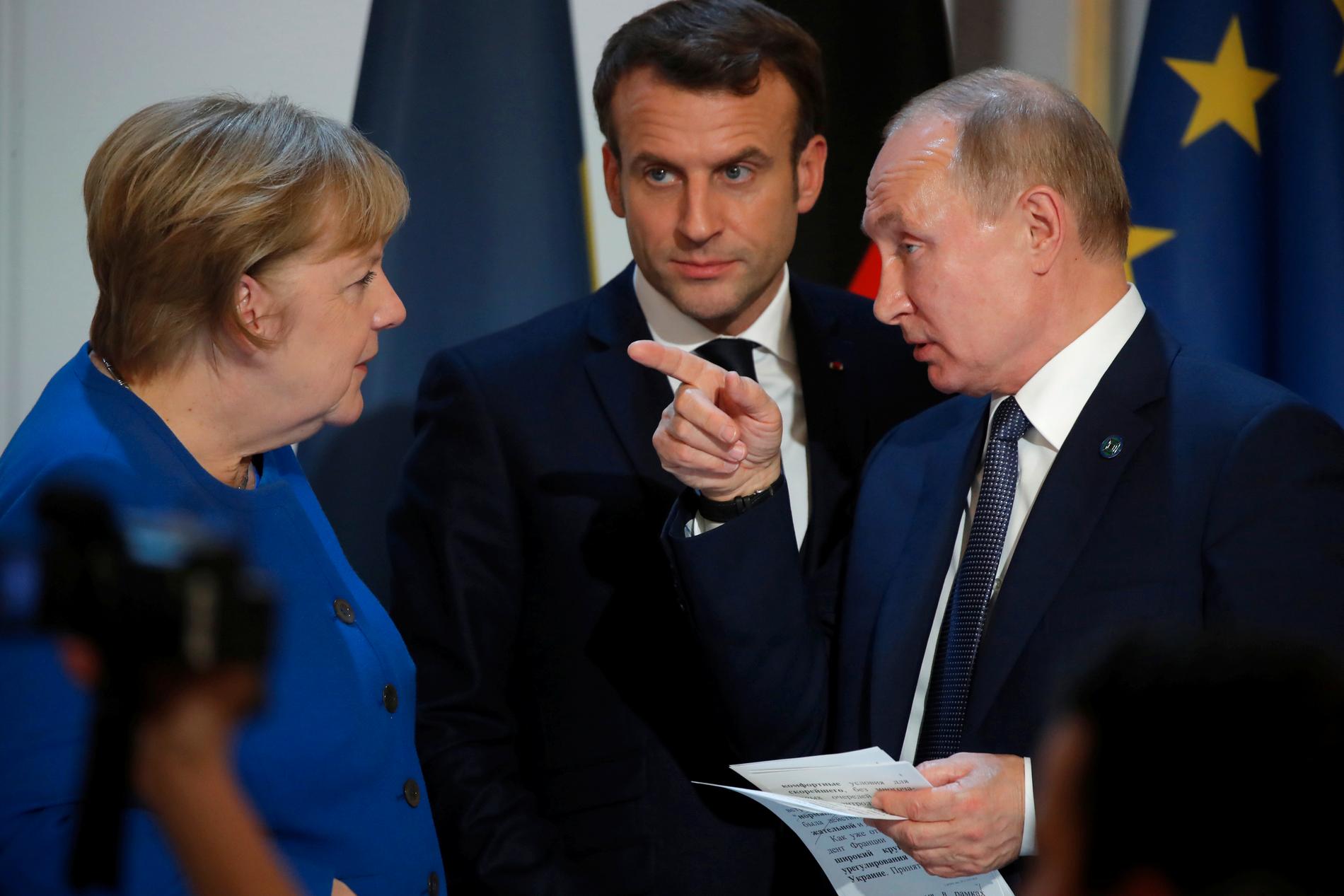 Tysklands förbundskansler Angela Merkel i samspråk med Rysslands president Vladimir Putin under en presskonferens i Paris i måndags. I bakgrunden den franske presidenten Emmanuel Macron. Arkivbild.