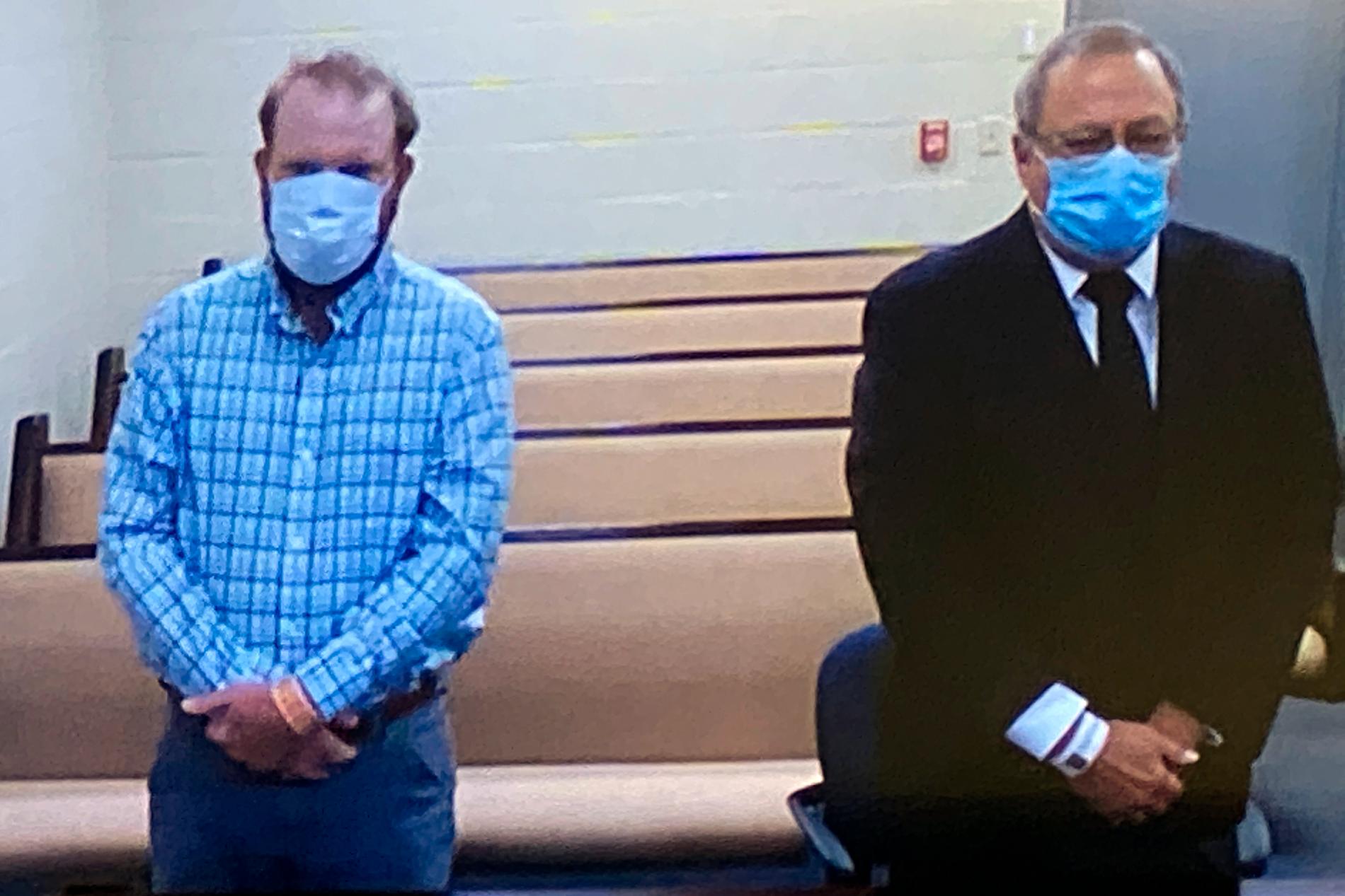 Två av de tre män som nu ställs inför rätta för Ahmaud Arberys död, son och far Travis McMichael och Greg McMichael, lyssnar via videolänk på domstolsförhandlingen.