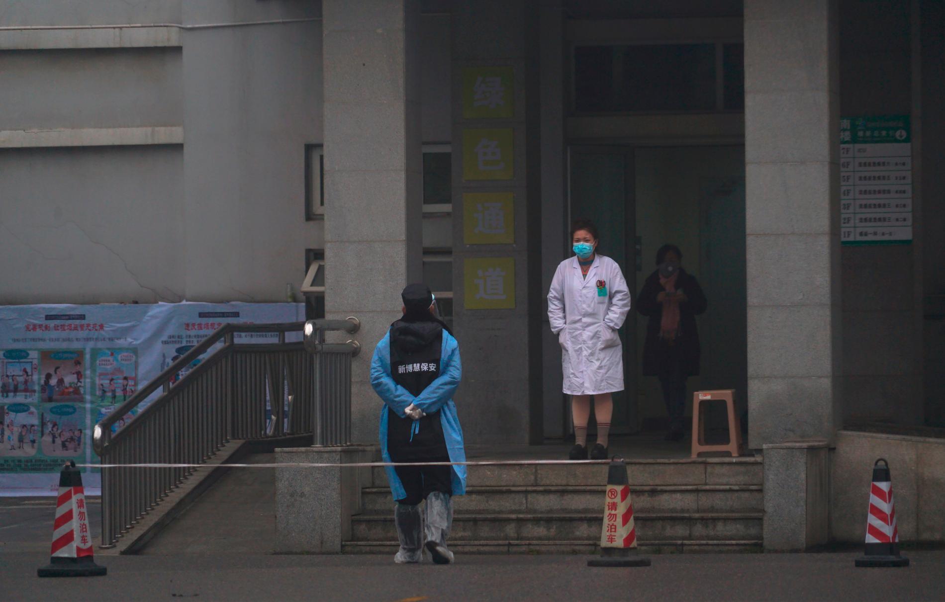 Sjukhuspersonal utanför akutmottagningen i Wuhan, där vissa smittade vårdas. 