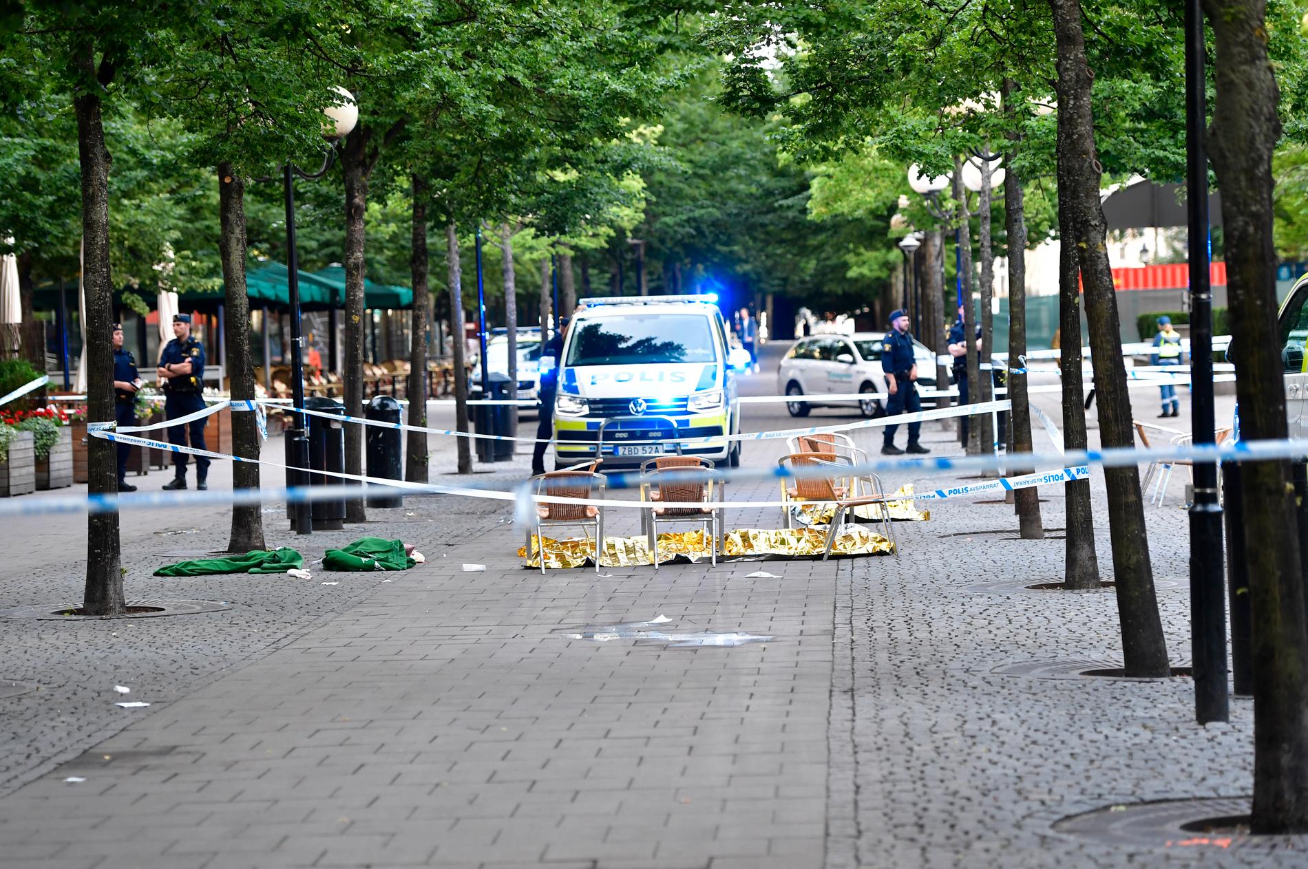 Polisen arbetar innanför avspärrningarna efter att flera personer knivhöggs i Kungsträdgården och på Västra Trädgårdsgatan i Stockholm i onsdags.