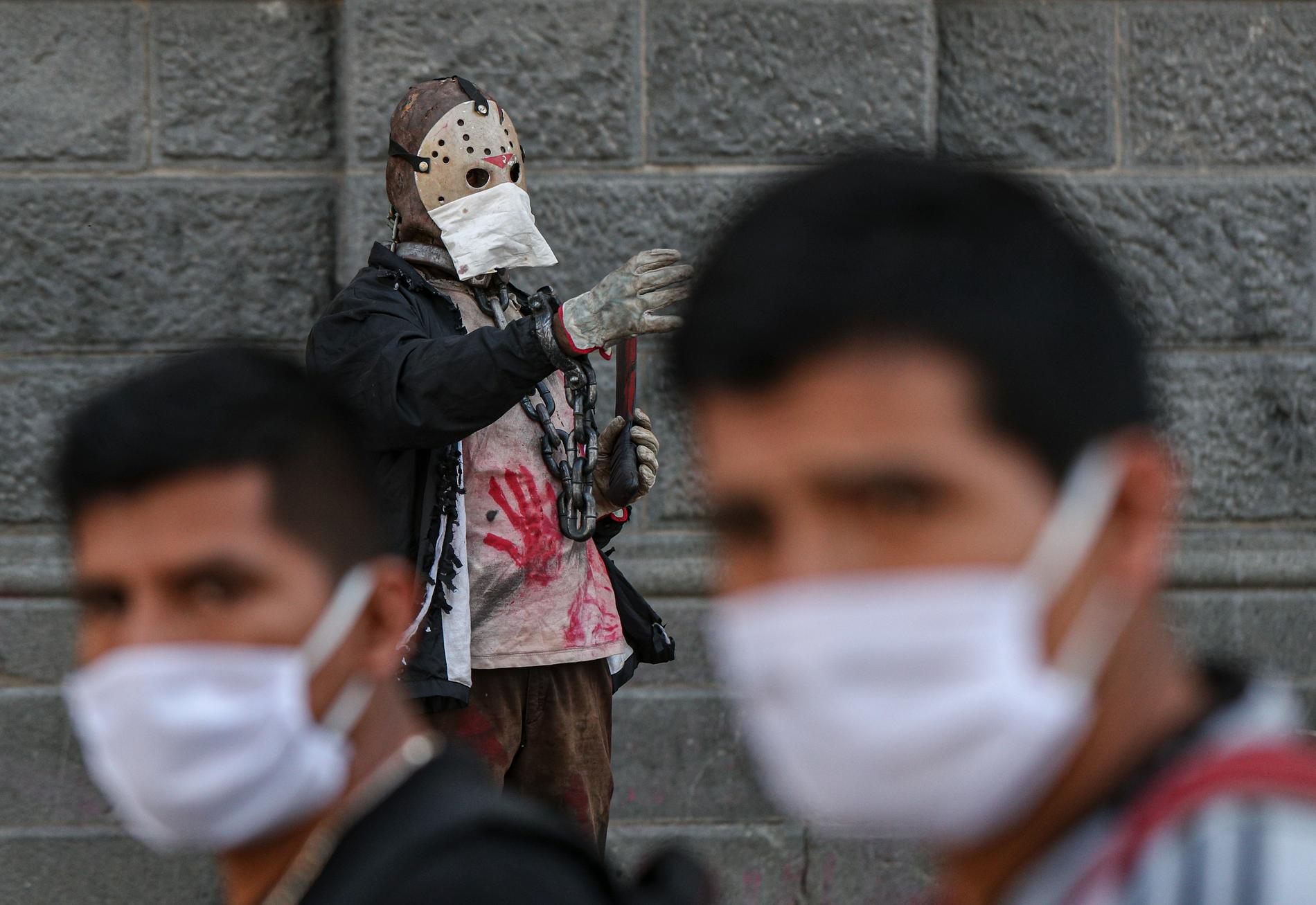SANTIAGO, CHILE En gatuartist utklädd till mördaren Jason Vorhees har tagit det säkra före det osäkra och toppat utstyrseln med ett munskydd.