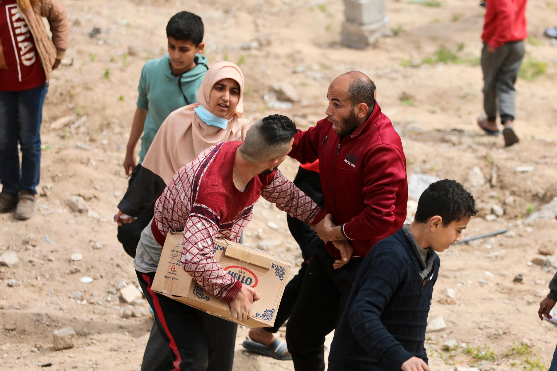 Människor springer fram för att ta del av ett matpaket som släpps från luften i Gaza City, 17 mars. 
