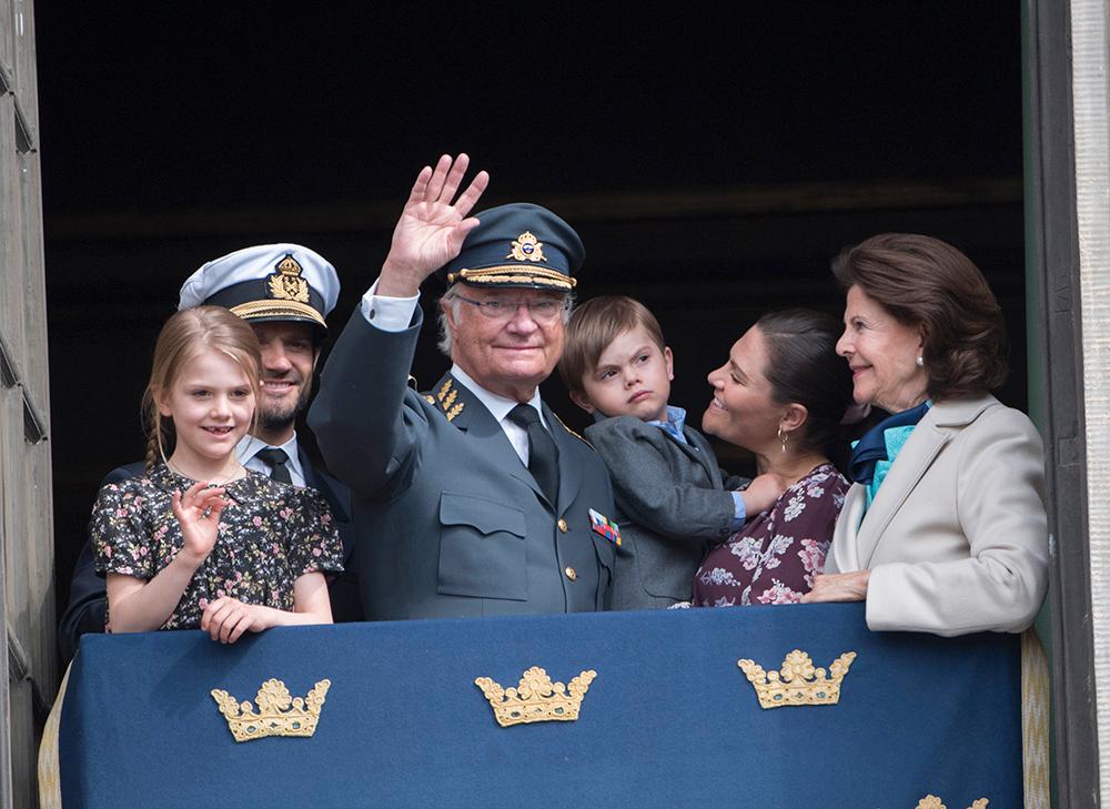 Prinsessan Estelle, prins Carl Philip, kung Carl XVI Gustaf, prins Oscar, kronprinsessan Victoria och drottning Silvia visar upp sig i slottets fönster under födelsedagsfirandet av kungen på Stockholms slott.