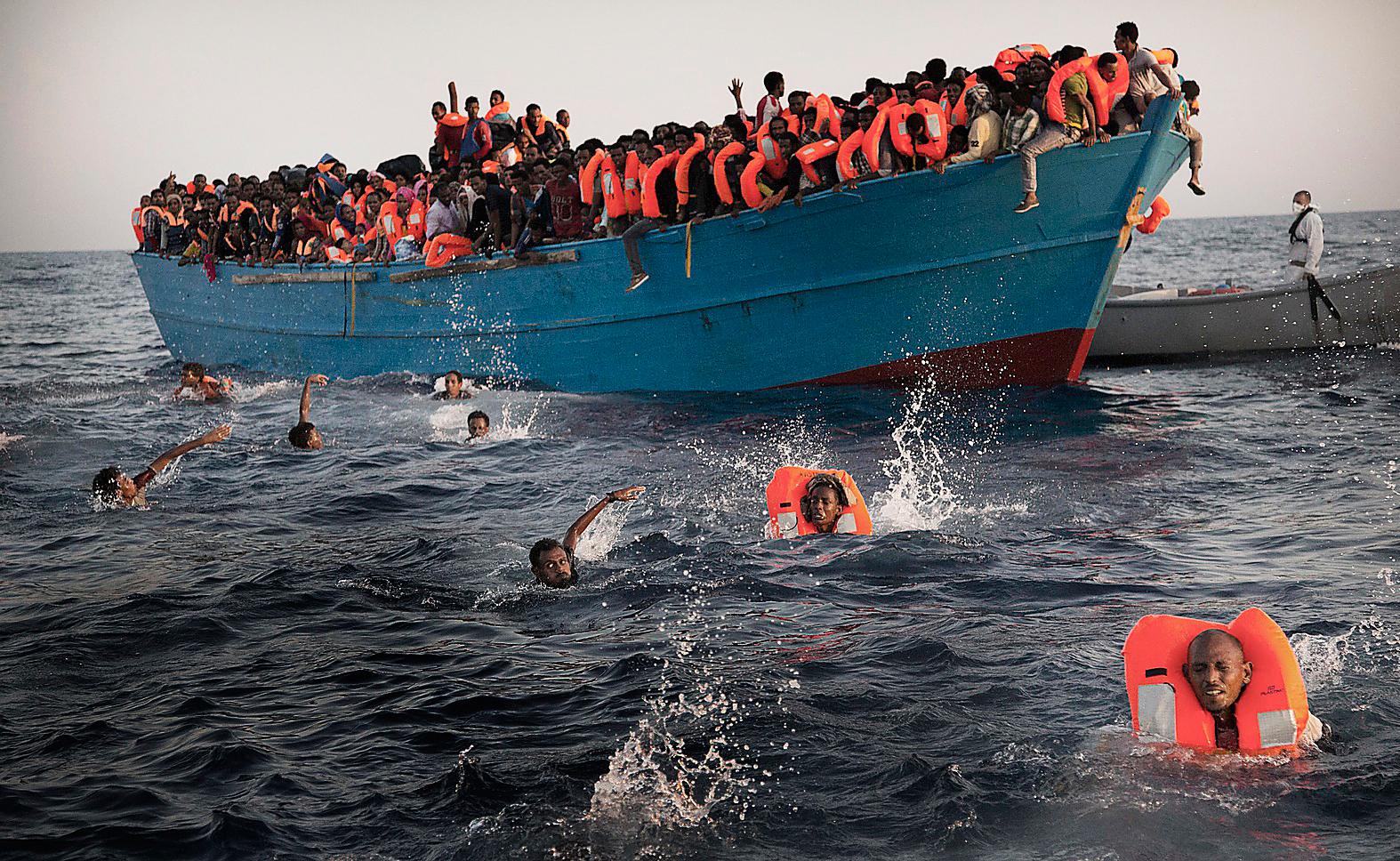 Afrikanska båtflyktingar kämpar för sina liv i Medelhavet.