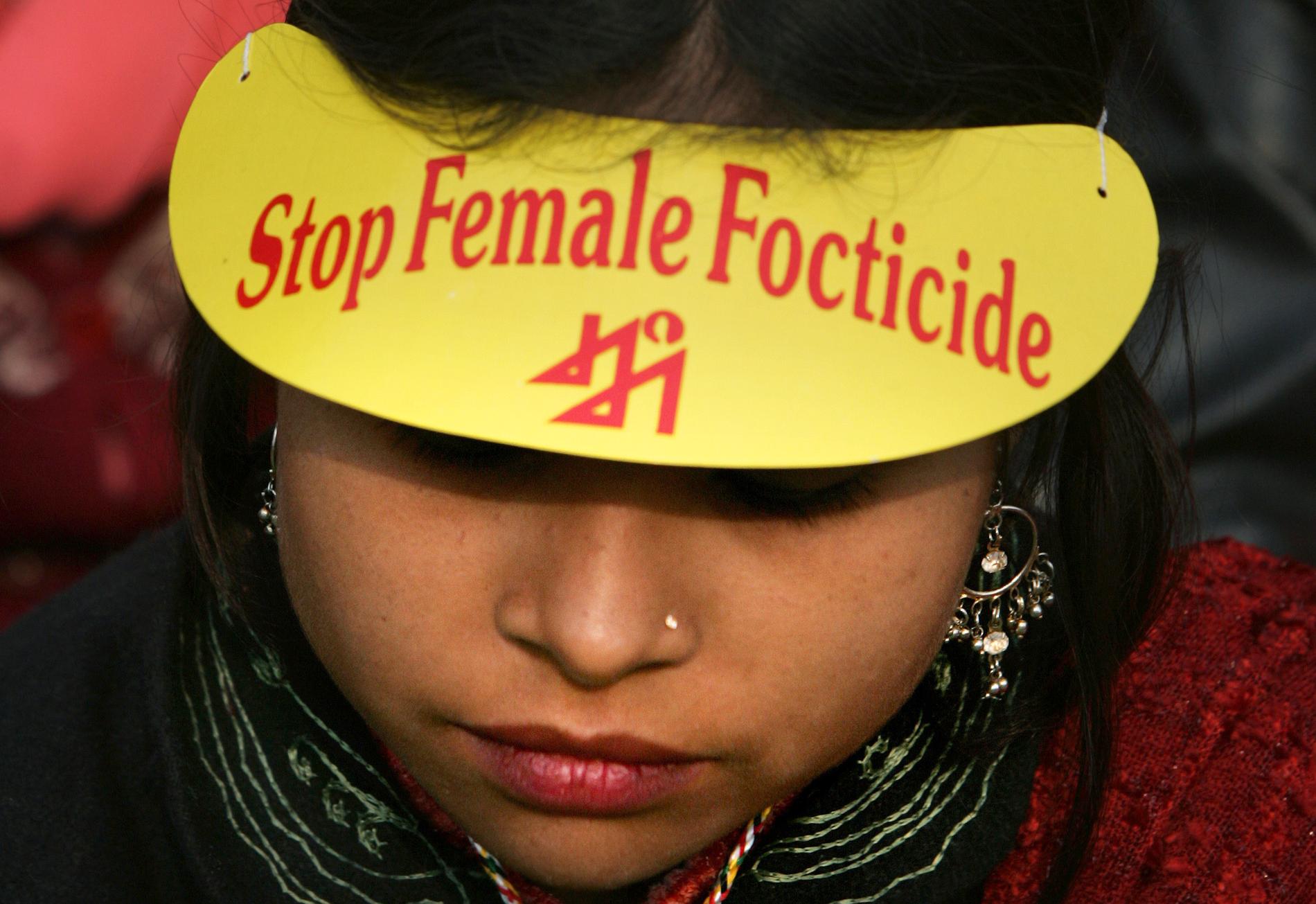 En kvinna deltar i en demonstration mot selektiva aborter på flickfoster i New Delhi, Indien. Arkivbild